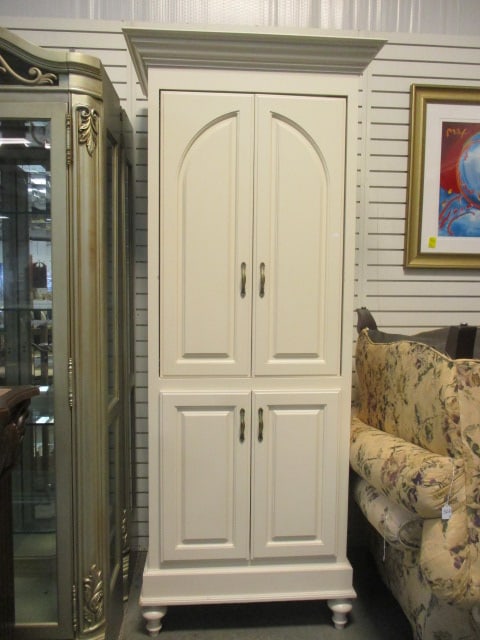 Painted Ivory Tall 4 Raised Panel Door Multi-Purpose Cabinet: 36 1/2" x 26 1/2" x 87 3/4", upper section has sliding pocket doors and removable shelf, shelf and back panel have gromet holes, lower section has hinged doors for storage, turned bun feet, sides