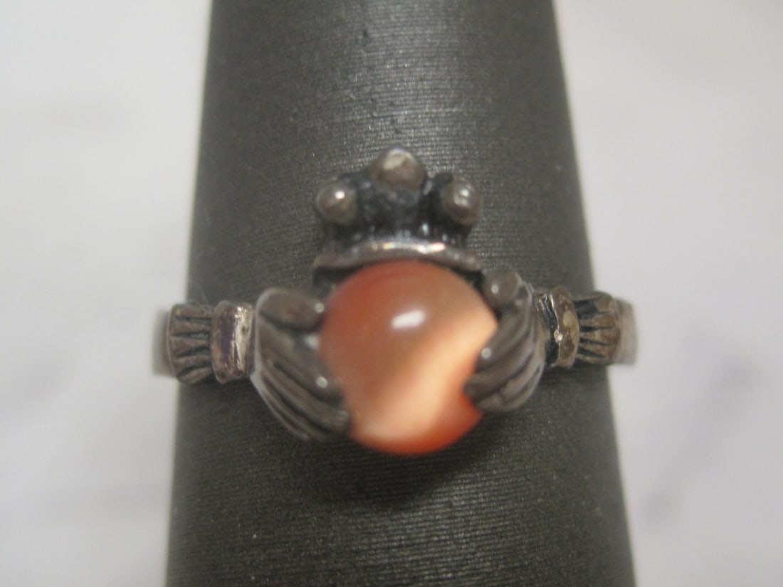 Sterling Silver Ring: Weighs 2.5 grams, Size 6, Featuring hand cradling a peach colored stone