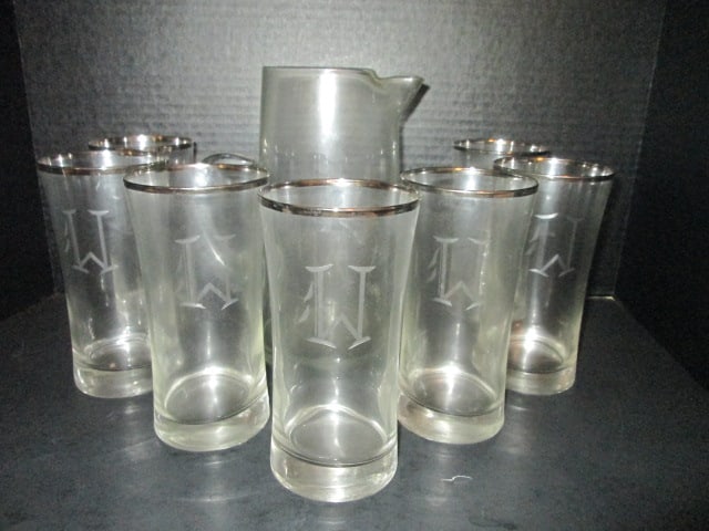 Silver Banded Tumbler and Pitcher Set with Cut "W" Monogram: (7)6 1/2"h tumblers, (1)8 3/4"h pitcher, glasses have silver band, pitcher is hand blown without silver band