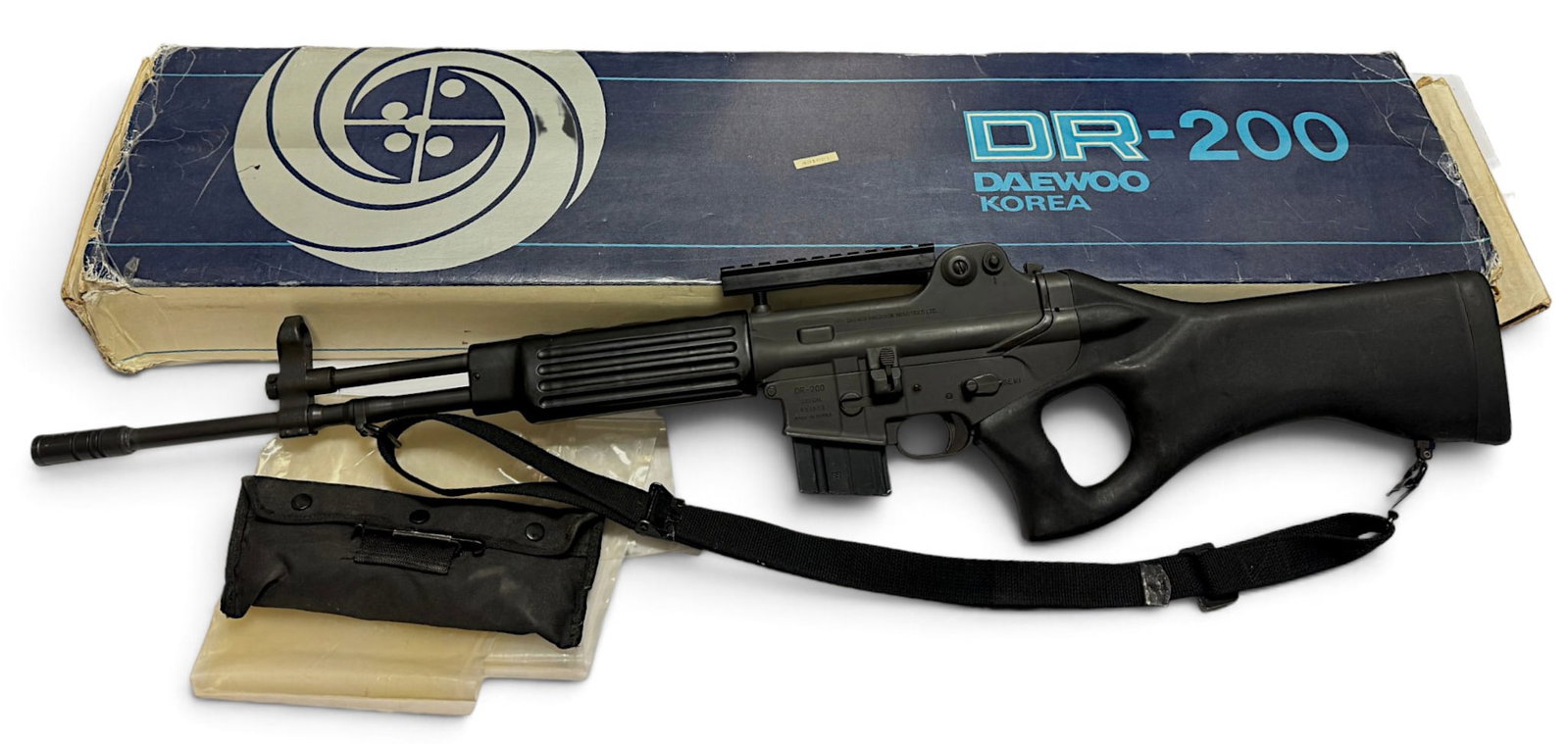 LNIB Scarce Korean DAEWOO DR-200 K2 Sporter .223 REM/5.56mm Rifle: S#: 431621 | 18” Barrel | Comes in factory box and outer sleeve with a matching label. Has (1) 10-Round Magazine | Black Sling & Factory Scope Rail Mount | These are civilian versions of the