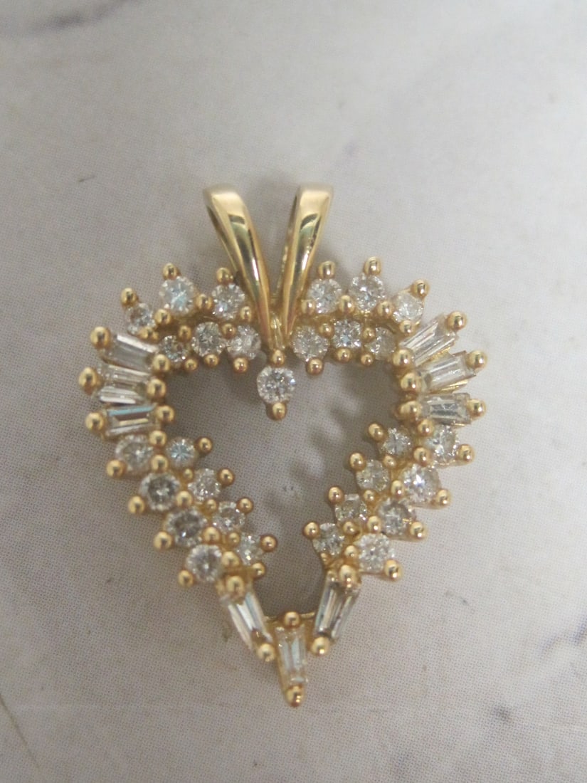 Diamond Heart Pendant appraised at $2,150: Weighs 2.7 grams, With 38 diamonds totaling 0.66 carat, yellow gold, 7/8", signed Keepsake, With appraisal of $2,150