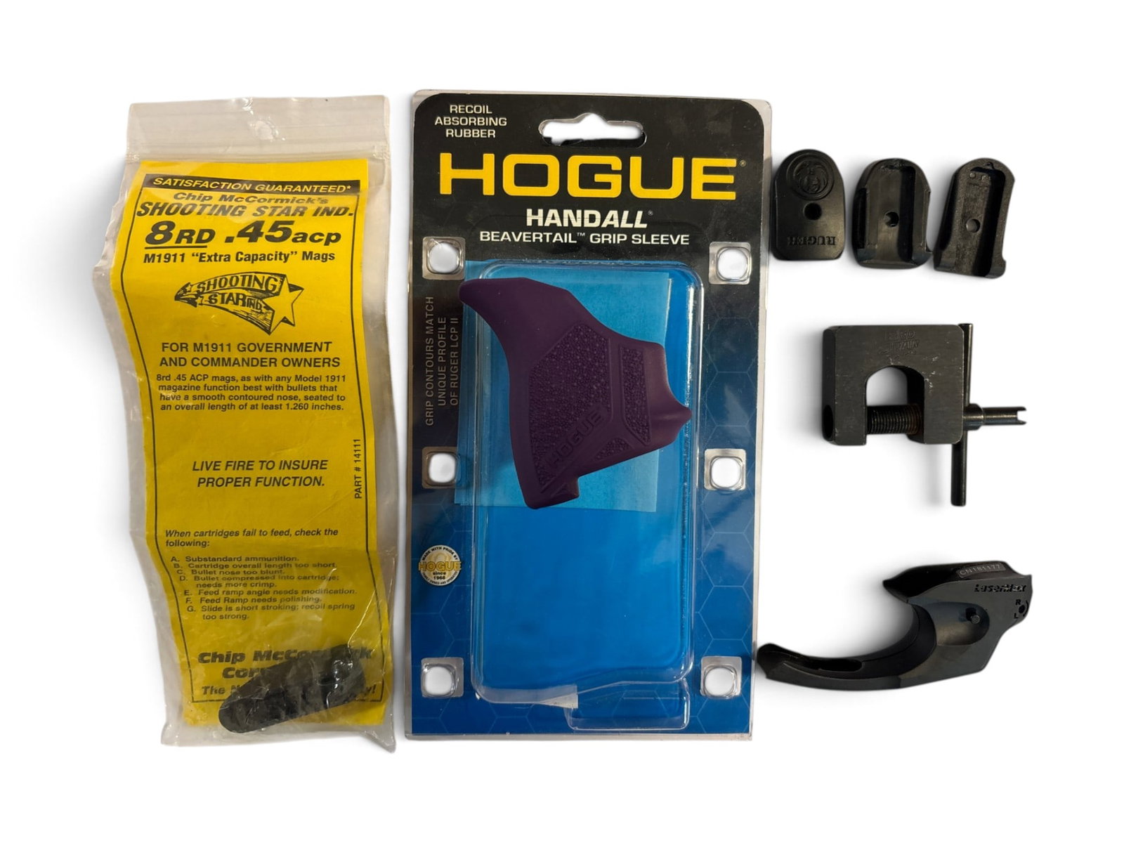 Assorted Gun Parts & Accessories: (1) LCP Hogue grip sleeve (1) sight adjustment tool (3) Ruger magazine baseplates (1) Ruger magazine loader, (1) trigger guard mounted laser