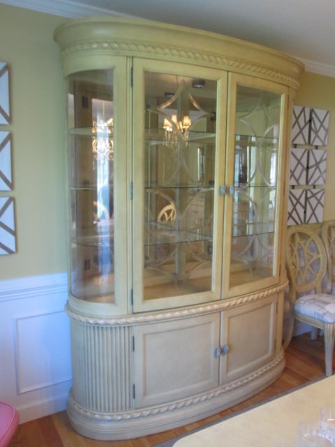 Hollywood Regency Neoclassical Style 2 Piece Curved Illuminated China Hutch: Oak Cream Semi-Opaque Stained Table with Banded Top Design, Curved Fluted "Column" Ends and Twisted Rope Molding. Measures 69" x 17 1/2" x 88"overall, China hutch has mirrored back with three glass