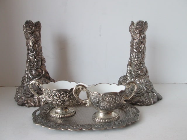 Pair of Floral Ribbon Silverplated Candle Sticks and Silverplated Creamer/Sugar Set: with Underplate. Candle sticks 7 1/2"h, Creamer/sugar set-2 3/4"h, underplate 8 1/8" x 4 5/8", creamer and sugar bowl have enamel interior bowls