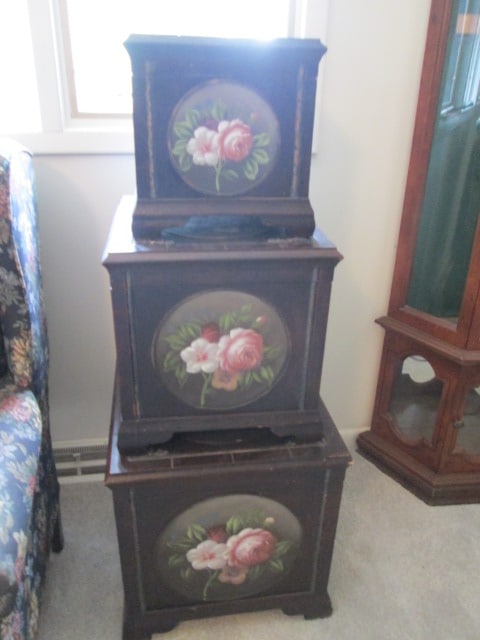 3 Piece Decorative Nesting Box/Trunk Set with Hand Decorated Flower Blossom Motif: 12 1/4"square x 12 1/4"h(one swan neck bail handle is broken but present), 15 3/4" x 15 1/2" x 16", 19"square x 19 3/4"(both swan neck bail handles are broken-one is present), some scuffs and