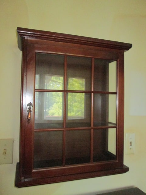 Wood Wall Mounted Display Cabinet: 19" x 7 1/2" x 23 1/4", glass sides and door, two wood shelves, cabinet was being used in smoker's office, some odor residue, preview suggested, Local Pickup Only