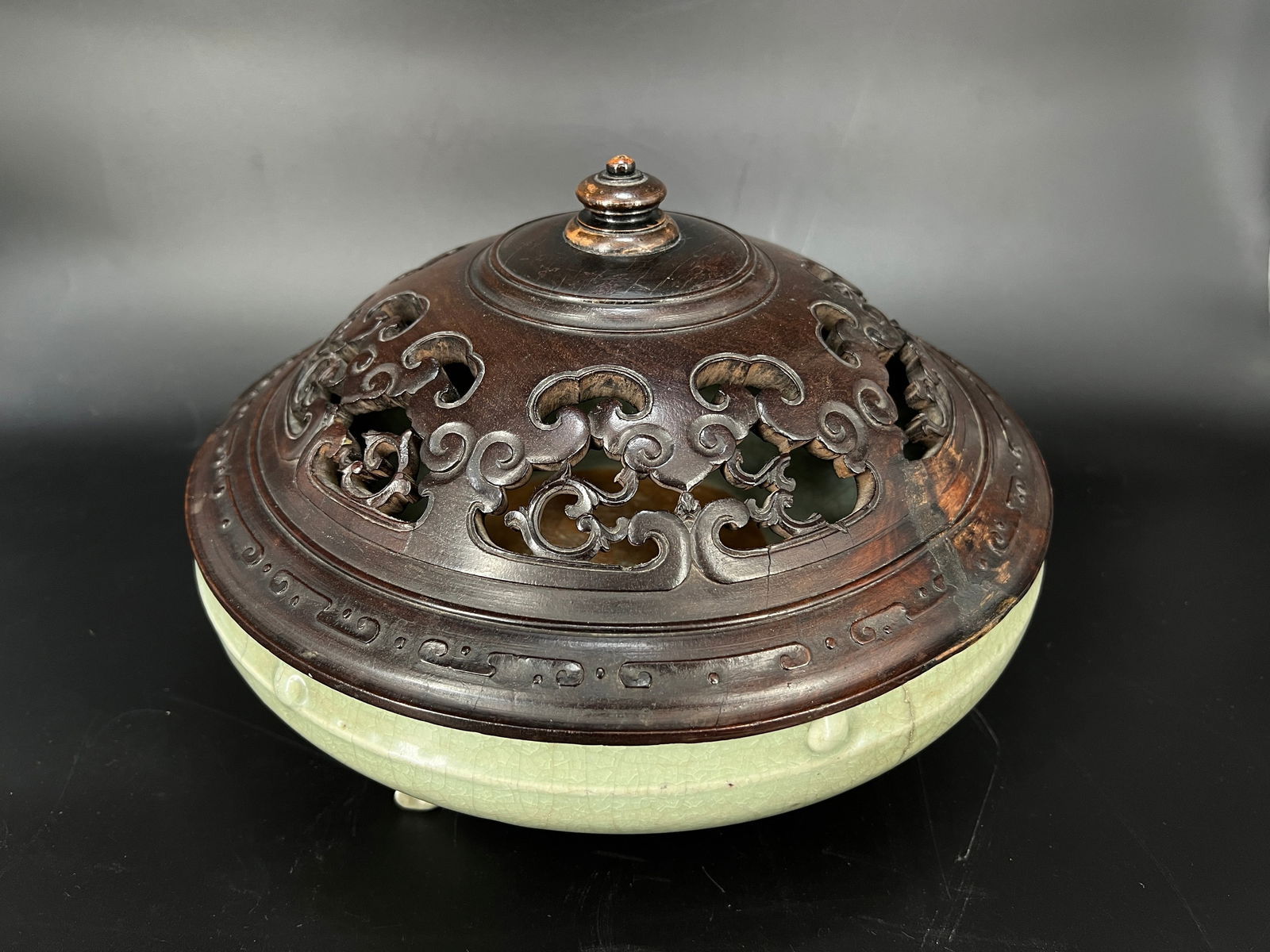 Yuan-Ming Dynasty Longquan Ware Drum-Nail Chrysanthemum Three-Legged Censer with Wooden Cover: H:9cm W:28cm. Ming Dynasty Longquan Celadon Tripod Washer with Drumhead Studs (with carved rosewood cover). Core materials: Longquan celadon (celadon glaze), rosewood (zitan) openwork cover. Dating: M