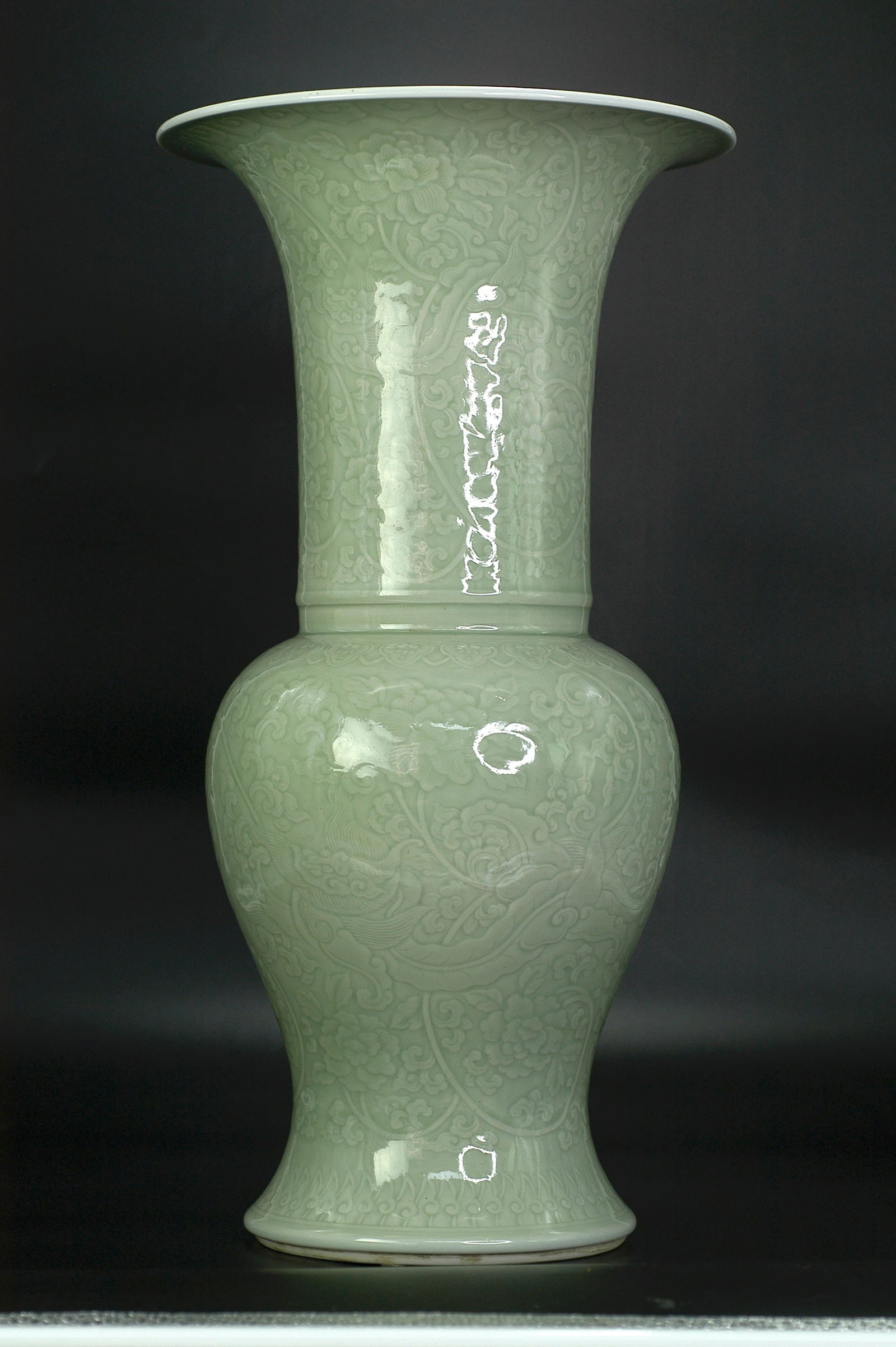 Qing Dynasty Pea-Green Glaze Low-Relief Dragon among Flowers Dish-Mouth Vase: H:44cm W:17cm. Qing Kangxi period (1662-1722) folk kiln imperial style fine quality phoenix tail zun (flower vase) with flared rim, narrow neck, bulbous body and ring foot. Bean green glaze (powder bl