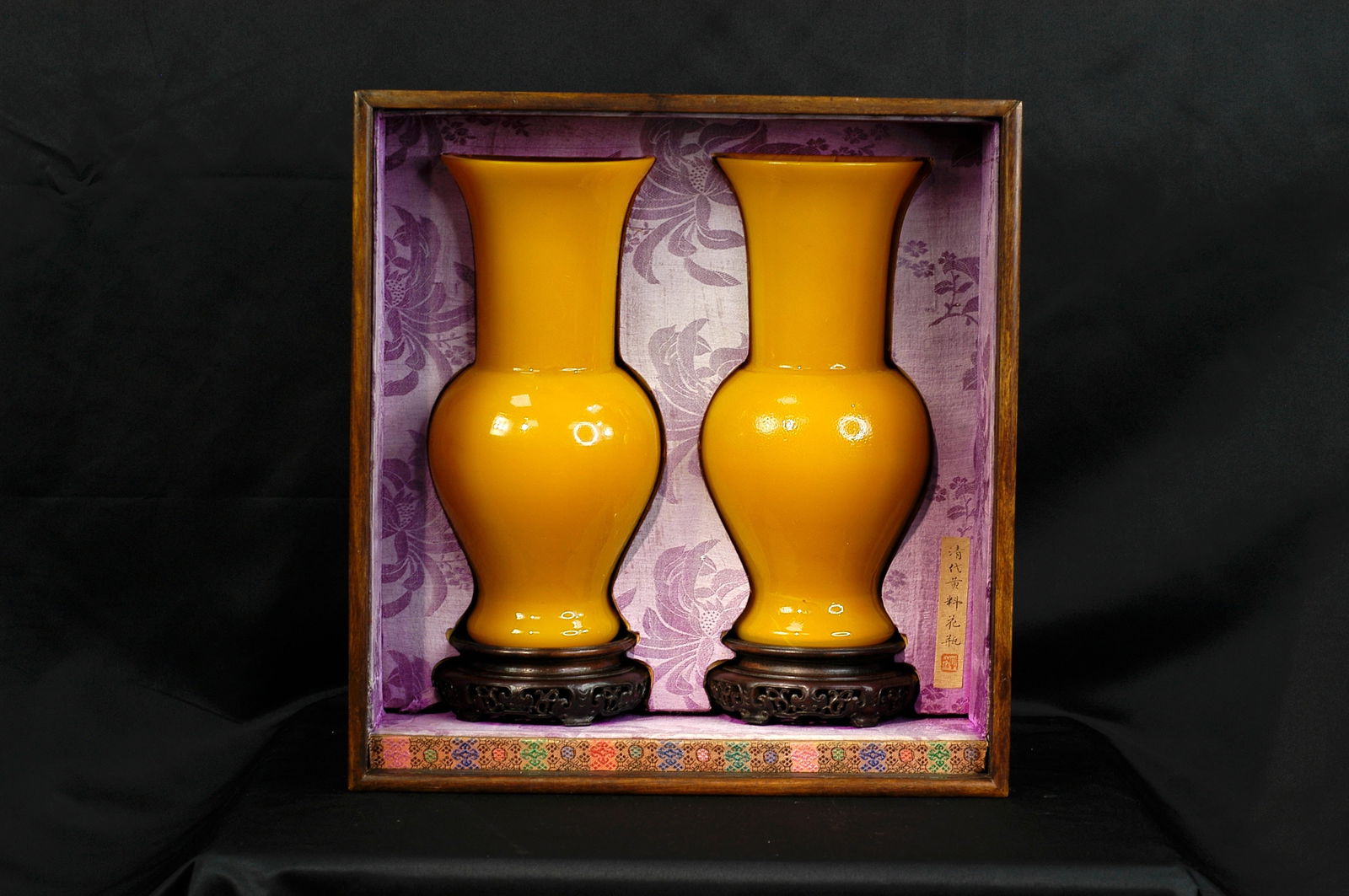 Republic Period or Later Yellow Glaze Guanyin Vase, a Pair (with Stand and Wooden Box): H 19.4cm, W 13cm. Qing Dynasty chicken-fat yellow glass huagu-form vase with flared mouth, constricted neck, bulging body, and ring foot. The semi-translucent buttery yellow glass exhibits rich, satur