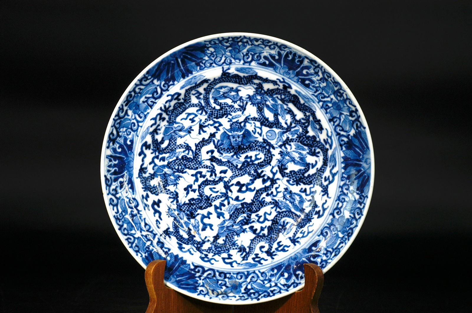 Qing Dynasty Blue and White Nine Dragons and Flowers Foliated Waisted Dish: H:3.5cm W:20.5cm Late Qing to Republic Period Blue-and-White Nine Dragons in the Sea Dish. Civilian kiln export porcelain with everted rim, curved walls, and ring foot. The cobalt blue shows purplish