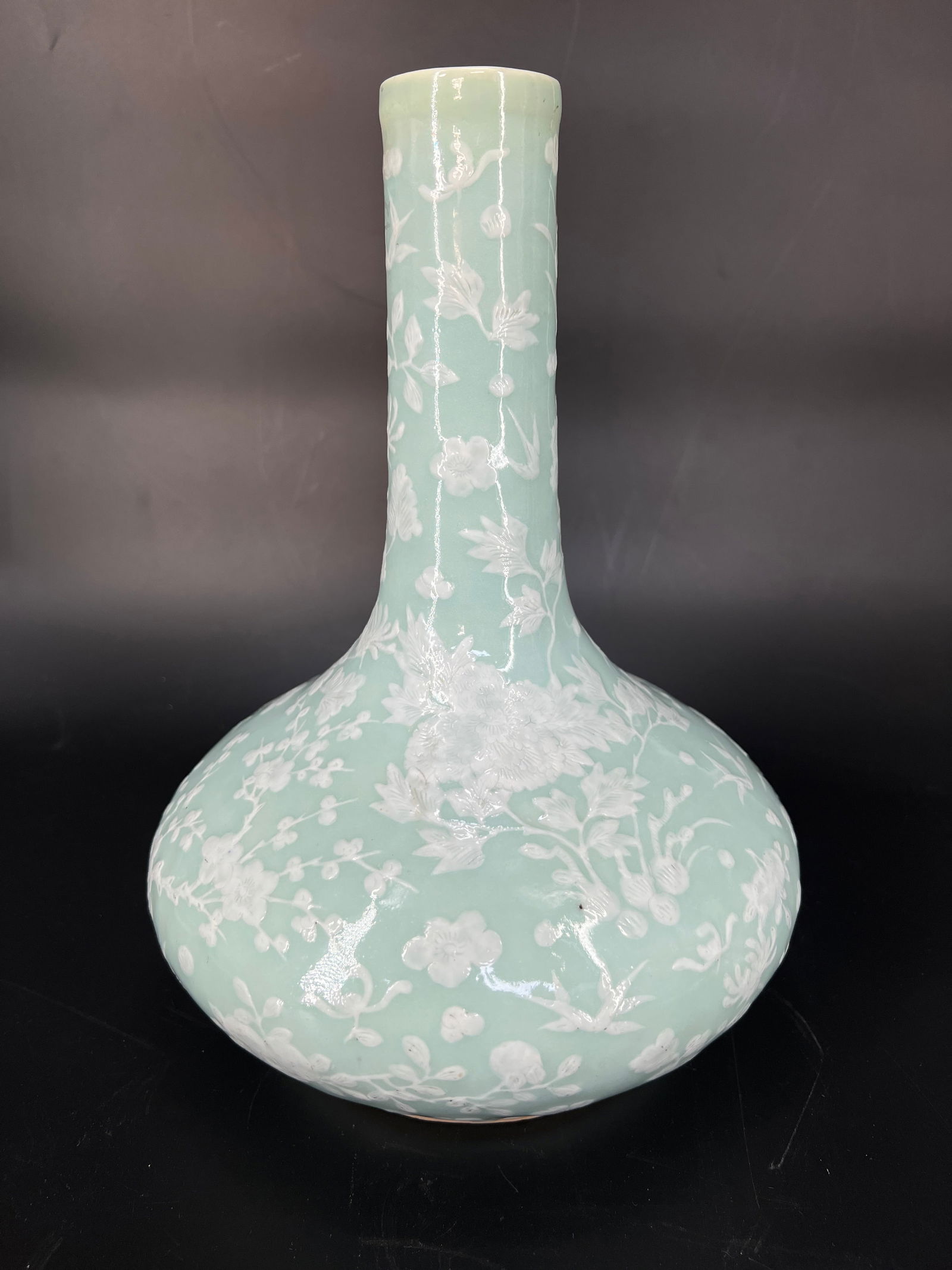 Qing Dynasty Pea-Green Glaze White Slip Floral Horseshoe Vase: H:30cm W:20cm Celadon-Glazed "Water Chestnut" Vase with Applied White Relief of Four-Season Flowers, Qing Dynasty. Jingdezhen celadon glaze (douqing) with applied white relief decoration. Mid-late Qin