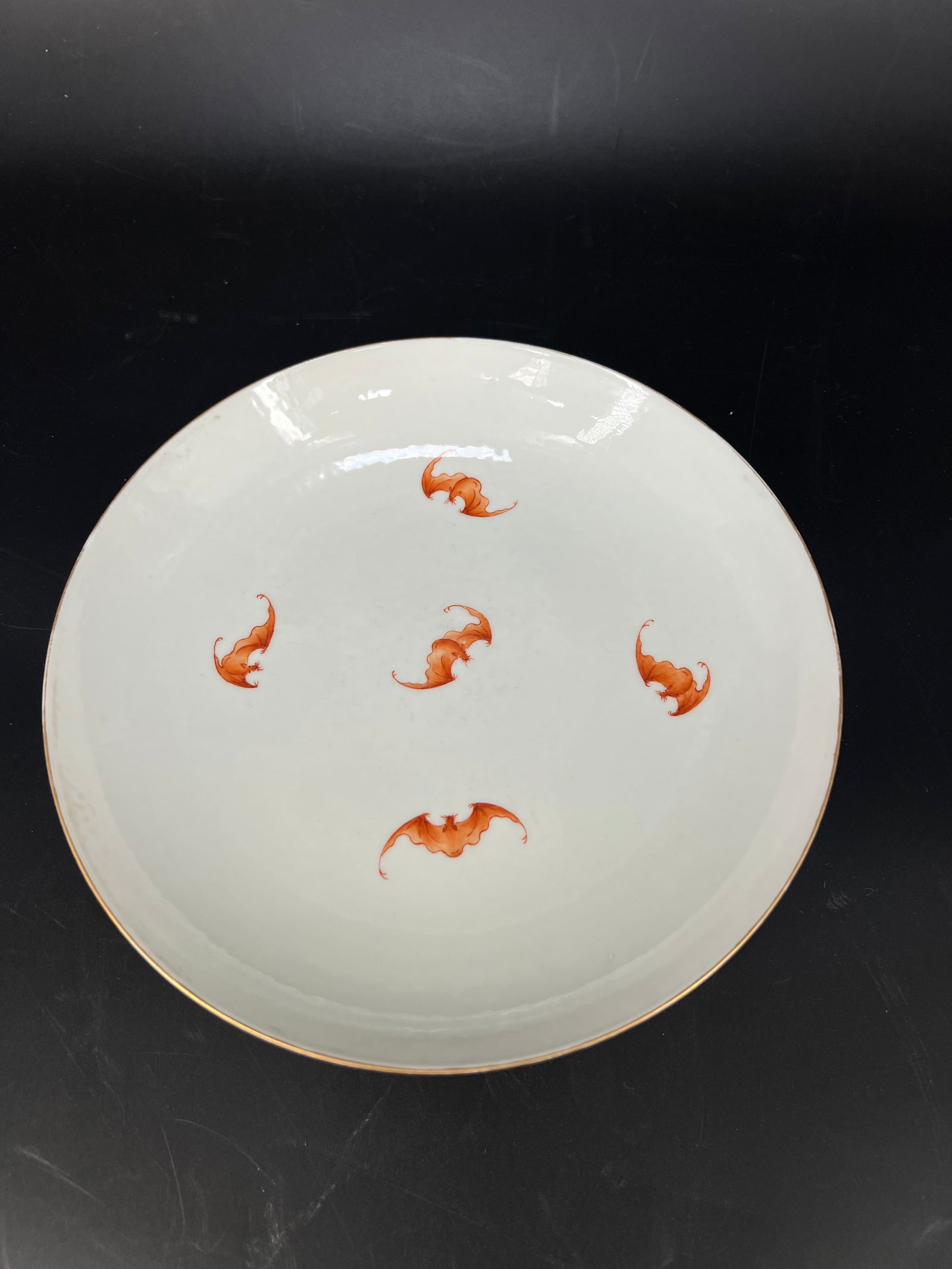 Qing Qianlong Crimson-Ground Famille Rose Five Bats Holding Shou Dish: H4.3cm W21.8cm - Qing Dynasty Qianlong Period Famille-Rose Plate with Five Bats Surrounding Longevity Symbol on Ruby Ground. Core material: Jingdezhen famille-rose porcelain with iron-red enamels on r
