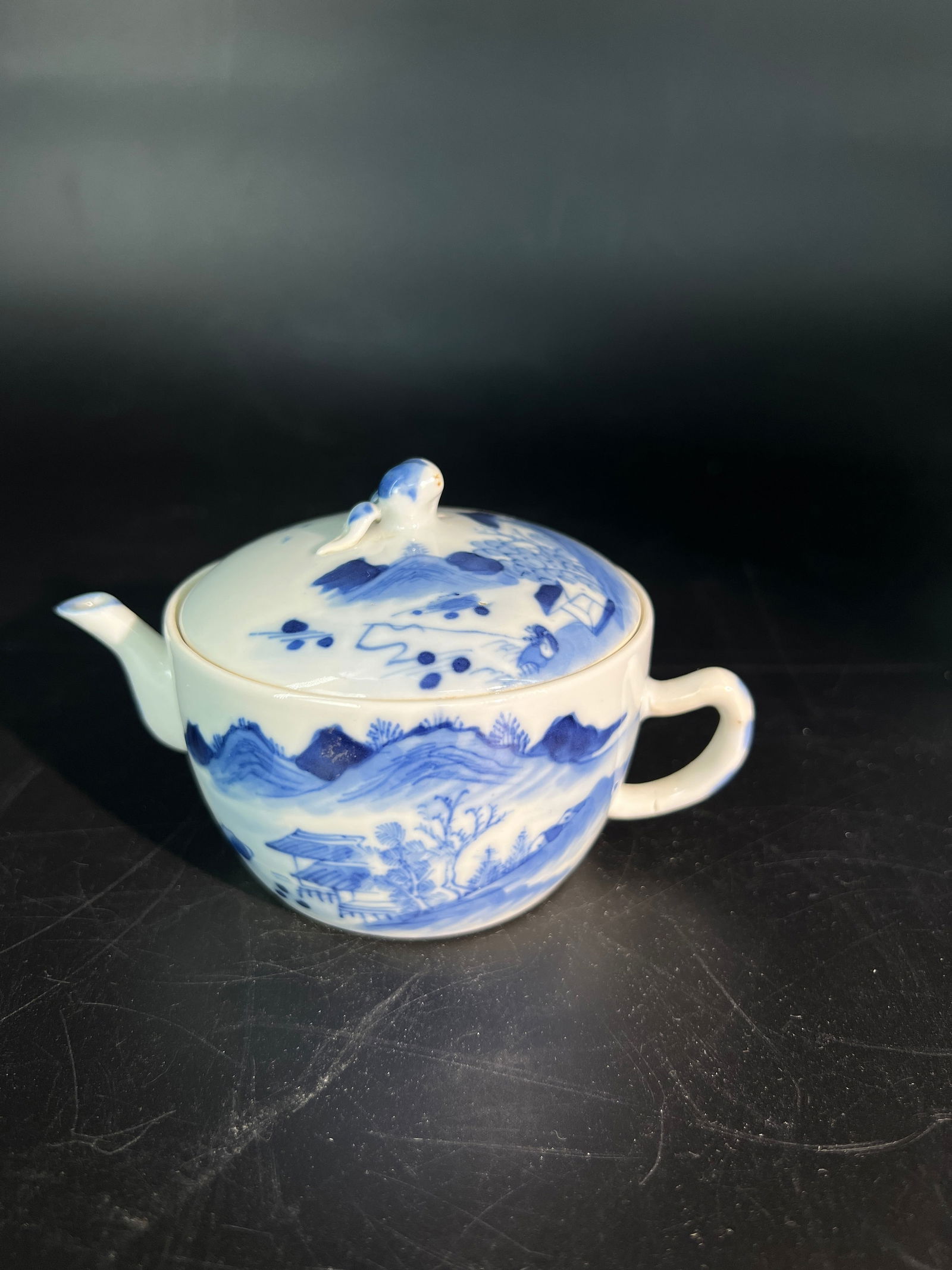 Late Qing Republic Blue and White Landscape Peach-Knop Teapot: H7CM W13CM - Late Qing to Republic Period Blue-and-White Teapot with Landscape Decoration and Peach-Shaped Finial. Core material: Jingdezhen blue-and-white porcelain with domestic cobalt pigment. Dati