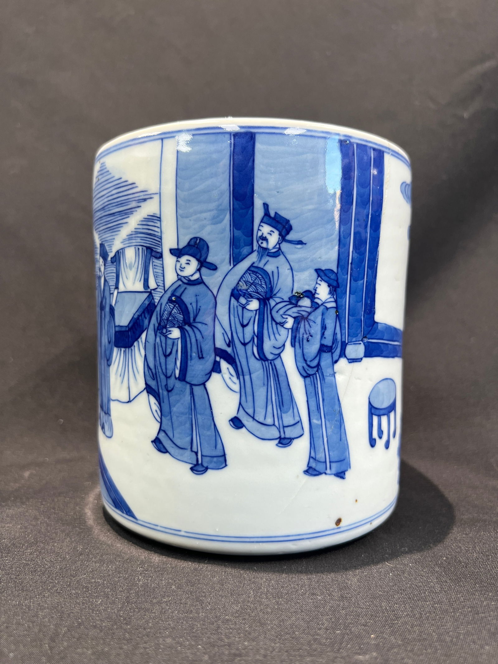 Qing Dynasty Blue and White Figural Narrative Brush Pot: H13.5cm W12.5cm. Qing Dynasty Kangxi Period - Blue and White Brush Pot with Figural Narrative Scene ('Eighteen Scholars' or 'West Garden Gathering' Subject). Essential Features: Form: Cylindrical shap