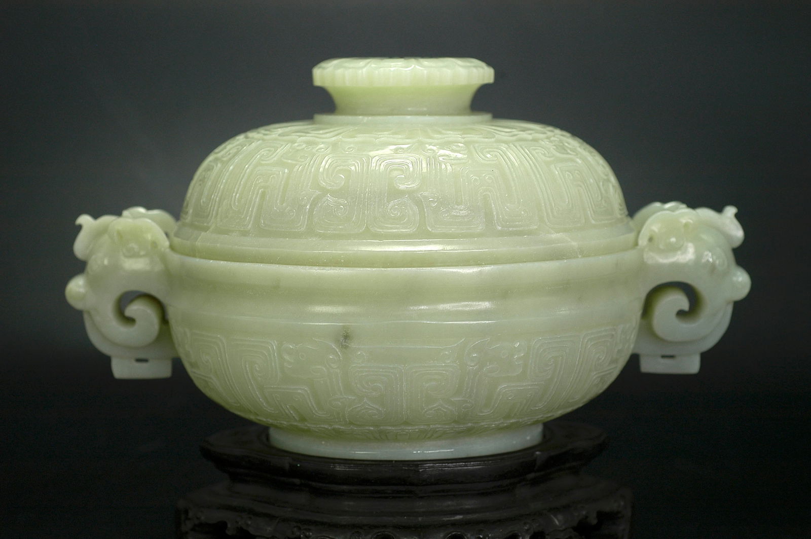Qing Dynasty Hetian Greenish-White Jade Double-Handle Dragon Covered Censer with Wooden Stand: H:12cm W:21cm Object Designation: Mid Qing Dynasty (Qianlong–Jiaqing) Xinjiang Hetian Celadon-White Jade Archaistic Gui-Form Covered Censer with Beast-Mask Motifs and Double Dragon Handles. Dati