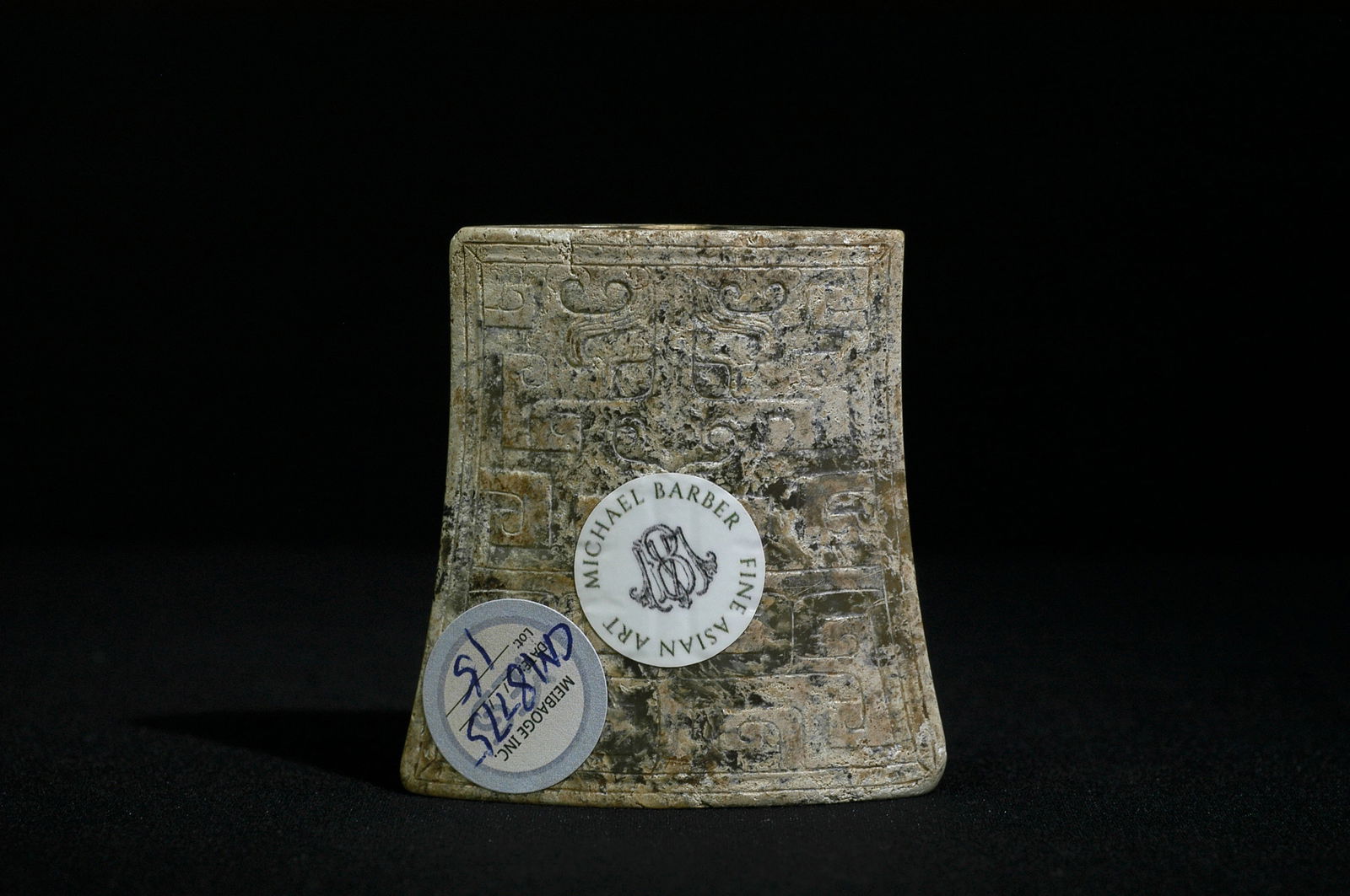 Warring States-Han Dynasty Greenish-White Jade Beast-Face Sword Guard: H5.8CM W5.5CM Warring States to Han Dynasty Jade Sword Chape. Form: Trapezoidal shape, wider at top and narrower below, with spindle-shaped sides and three holes at base (one large, two small) - stand