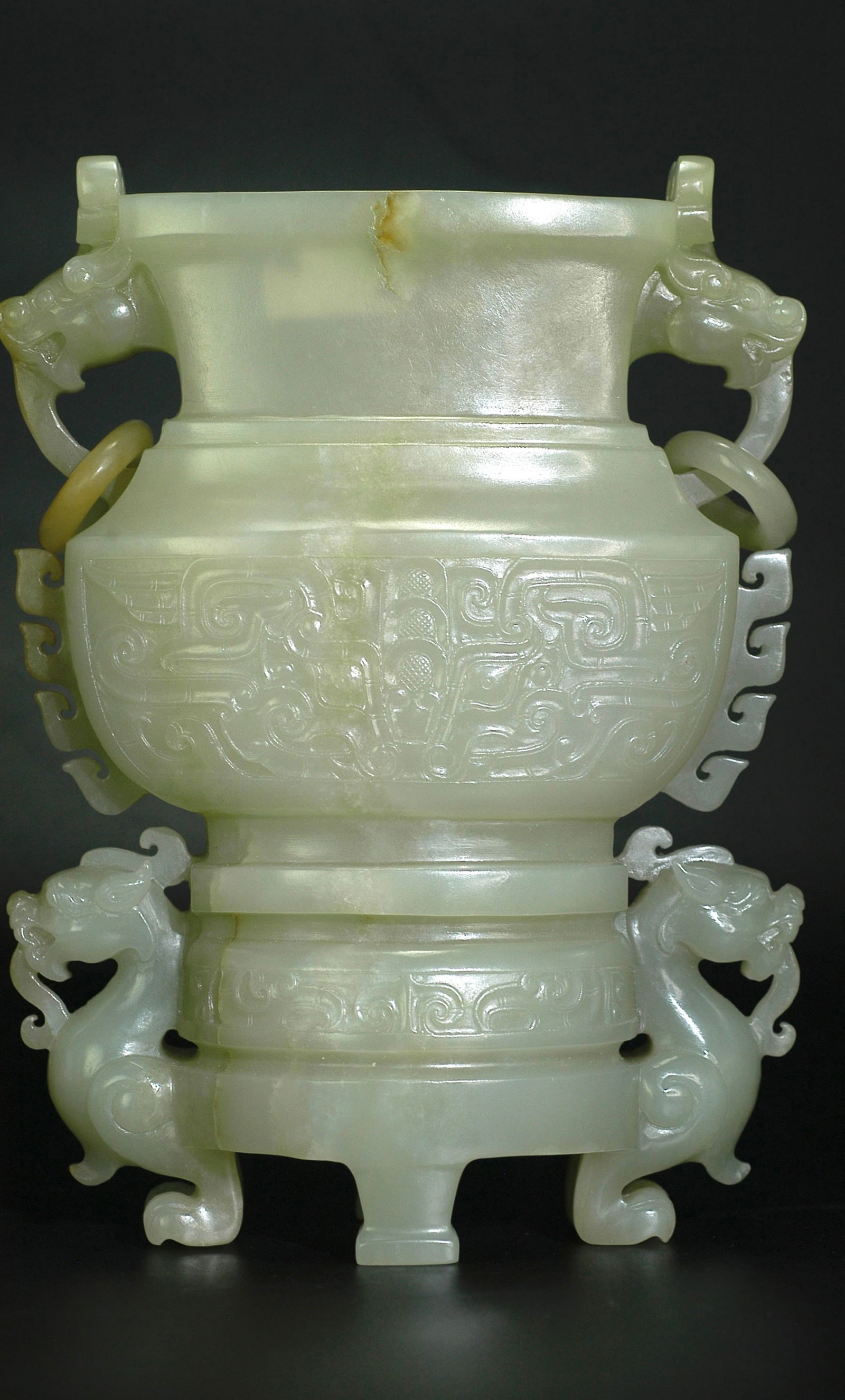 Qing Dynasty Hetian Greenish-White Jade Beast-Handle Ring Double Beast-Foot Vase (Missing Cover): H:19.3cm W:14cm Mid Qing Dynasty (Qianlong-Jiaqing) Xinjiang Hetian Celadon-White Jade Archaistic Zun Vessel with Beast-Mask Motifs, Double Dragon Handles with Loose Rings, and Three Beast Feet. Datin