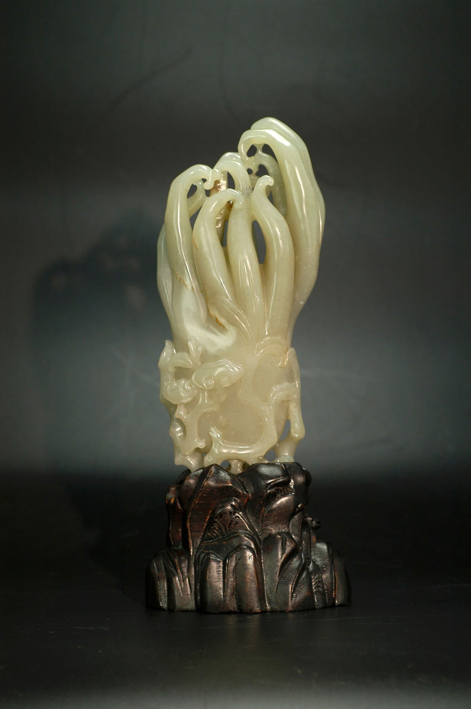 Qing Dynasty Hetian Greenish-White Jade Buddha's Hand Ornament: H18cm W9cm Qing Dynasty Hetian Jade Buddha's Hand Ornament with Lingzhi Motif. Material: Celadon-white jade with natural skin coloration and dark inclusions. Craftsmanship: Carved in the round with op