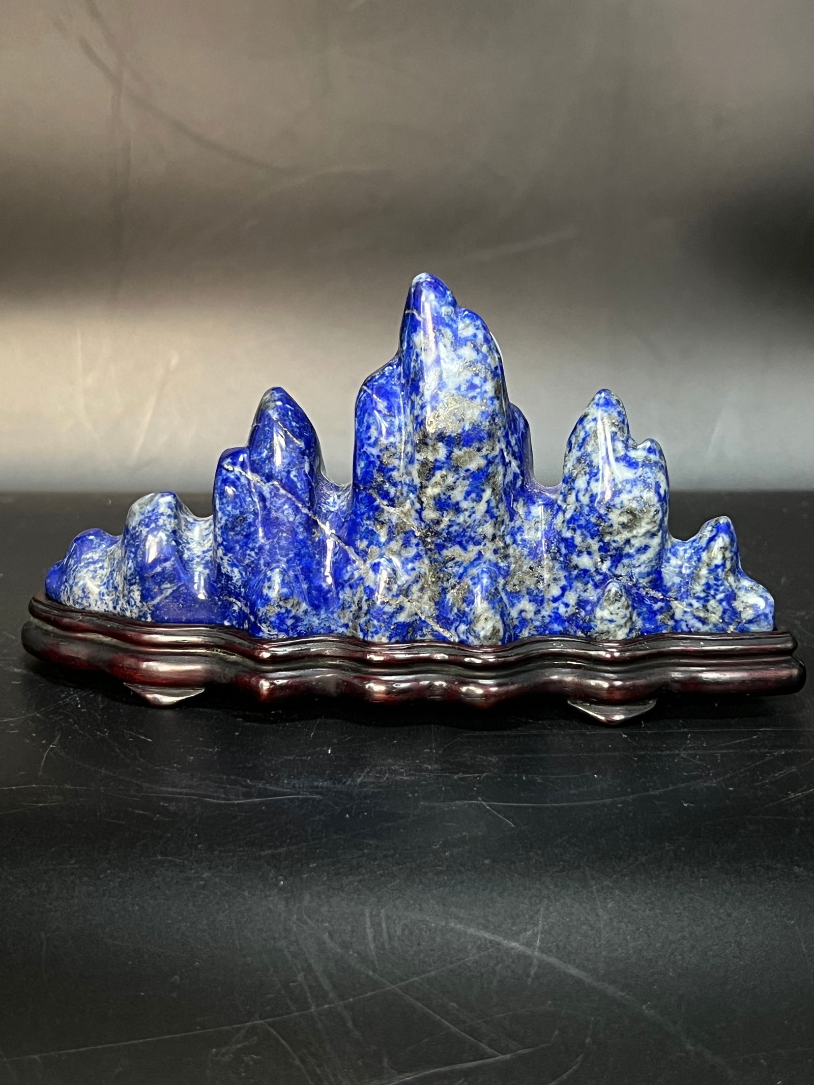 Republic Period Qing Jin Wax Stone Brush Rest with Wooden Stand: H:8cm W:15cm Lapis Lazuli Mountain-Form Brush Rest (scholar's desk ornament). Made of lapis lazuli with hongmu (or old hongmu) base. Mid to late Qing Dynasty to Republic period (approximately 18th-ear