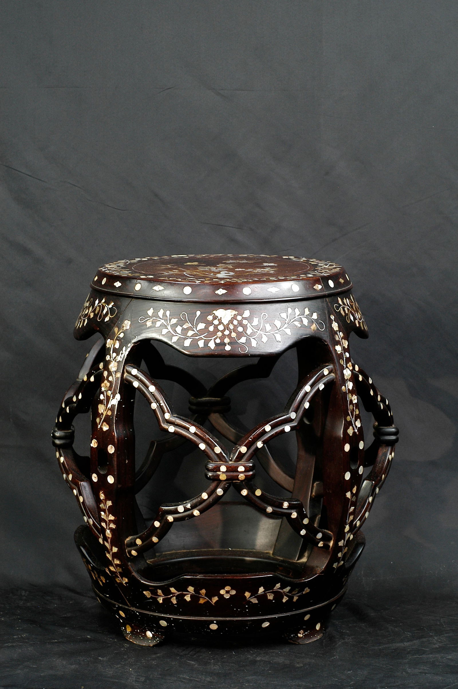 Qing Dynasty Wooden Butterfly Floral Drum Stool: H:53.5CM W:47CM Late Qing to Republic period Cantonese hongmu (or suanzhi wood) mother-of-pearl inlaid drum stool (embroidery stool). Drum-shaped form with studded bands top and bottom, double cross o