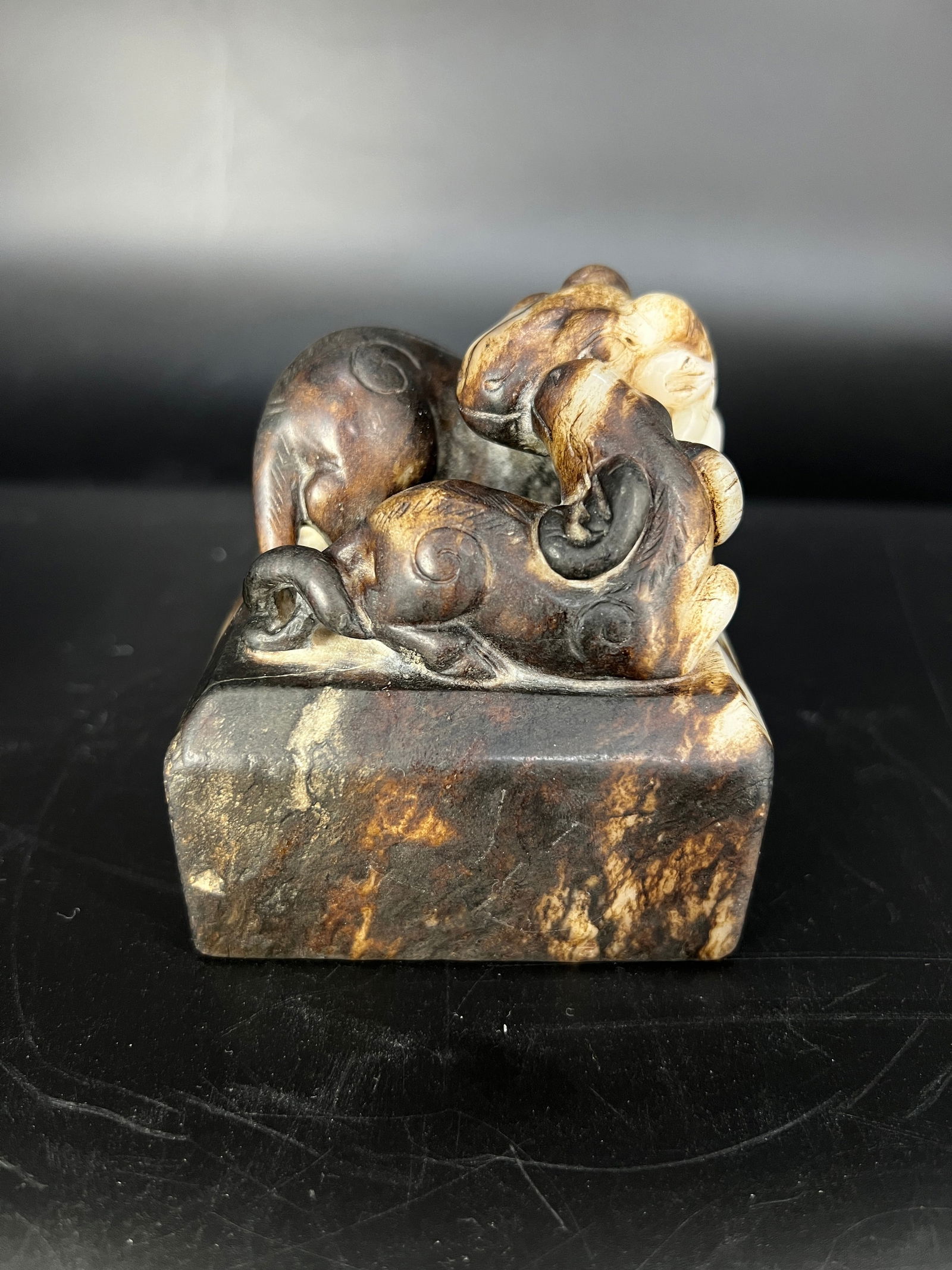 White Jade Black Oil-Inlaid Sheep Teaching Child Table Weight: H:8.4CM W:7.2CM White jade oil-treated 'Three Goats Bring Prosperity' finial square seal with rosewood box. Made from Hetian white jade (oil-treated for coloring). Mid to Late Qing Dynasty. Market ref