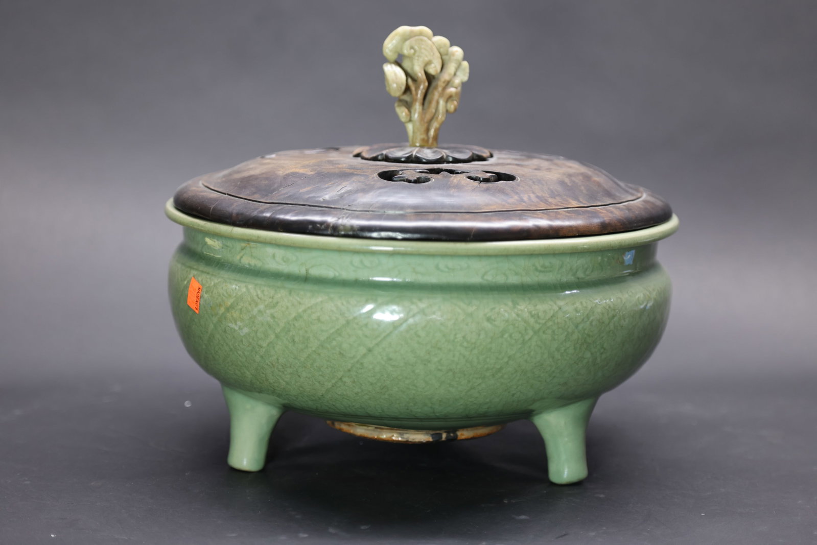 A 'Longquan' Celadon 'Floral' Tripod Censer, Ming Dynasty: Estimated Date: Mid to Late Ming Dynasty. Attributed to the Longquan kilns as a celadon tripod incense burner.Attribution: The censer is heavily potted and covered in a rich, thick powder-blue celadon