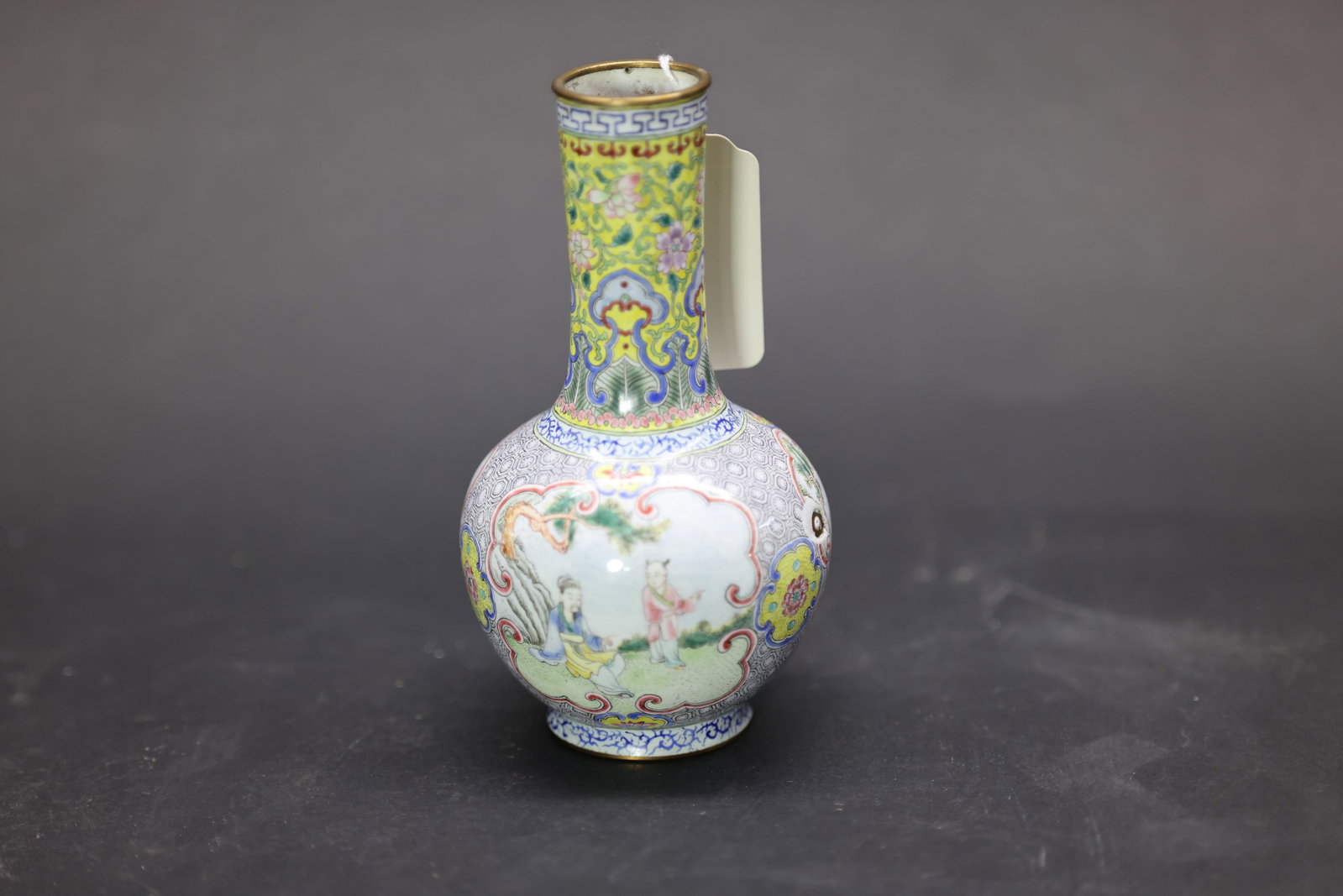 A Rare Small Canton Enamel Yellow-Ground 'Landscape and Figures' Tianqiuping, Late Qing Dynasty: Estimated Date: Late Qing Dynasty. A Canton enamel-on-copper vase made for display.Attribution: Finely crafted with a copper body, the vase features gilt-bronze mounts at the rim and foot. The neck is