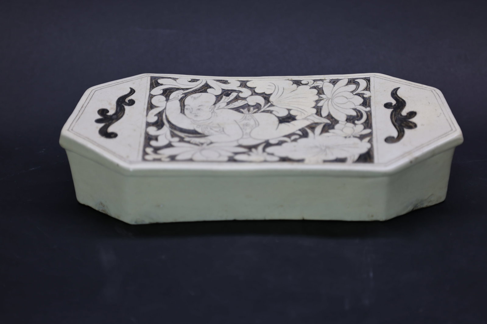 A 'Cizhou' White and Black-Cut 'Boy' Octagonal Pillow, Jin Dynasty (1 of 6)