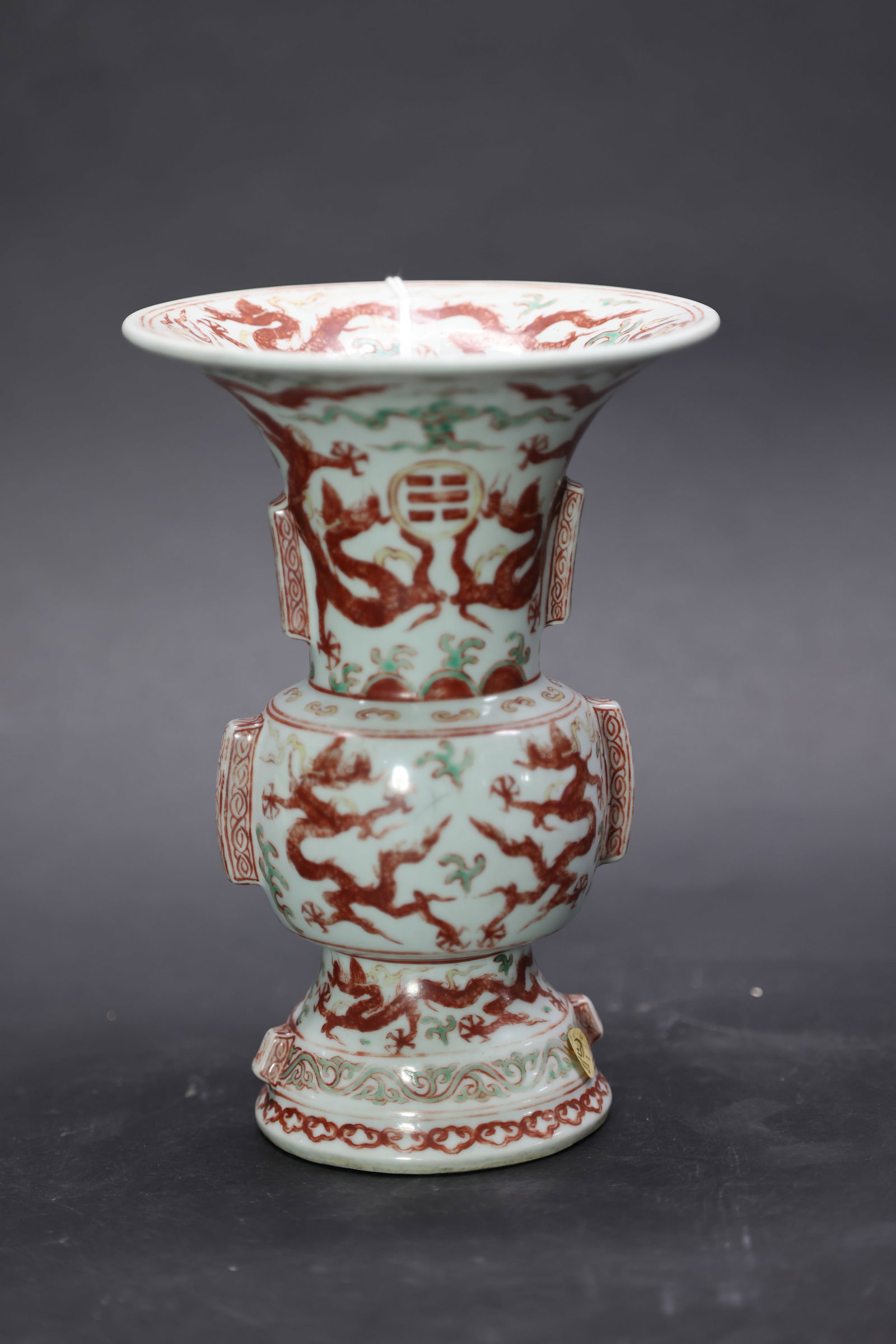 A Rare 'Wucai' and Iron-Red 'Dragon and Bagua' Flanged Gu-Vase, Jiajing Mark and Period: Estimated Date: Ming Dynasty, Jiajing Period. An imperial-style wucai vase in the archaic gu form, bearing a six-character Jiajing reign mark.Attribution: Modeled after an ancient bronze ritual gu ves