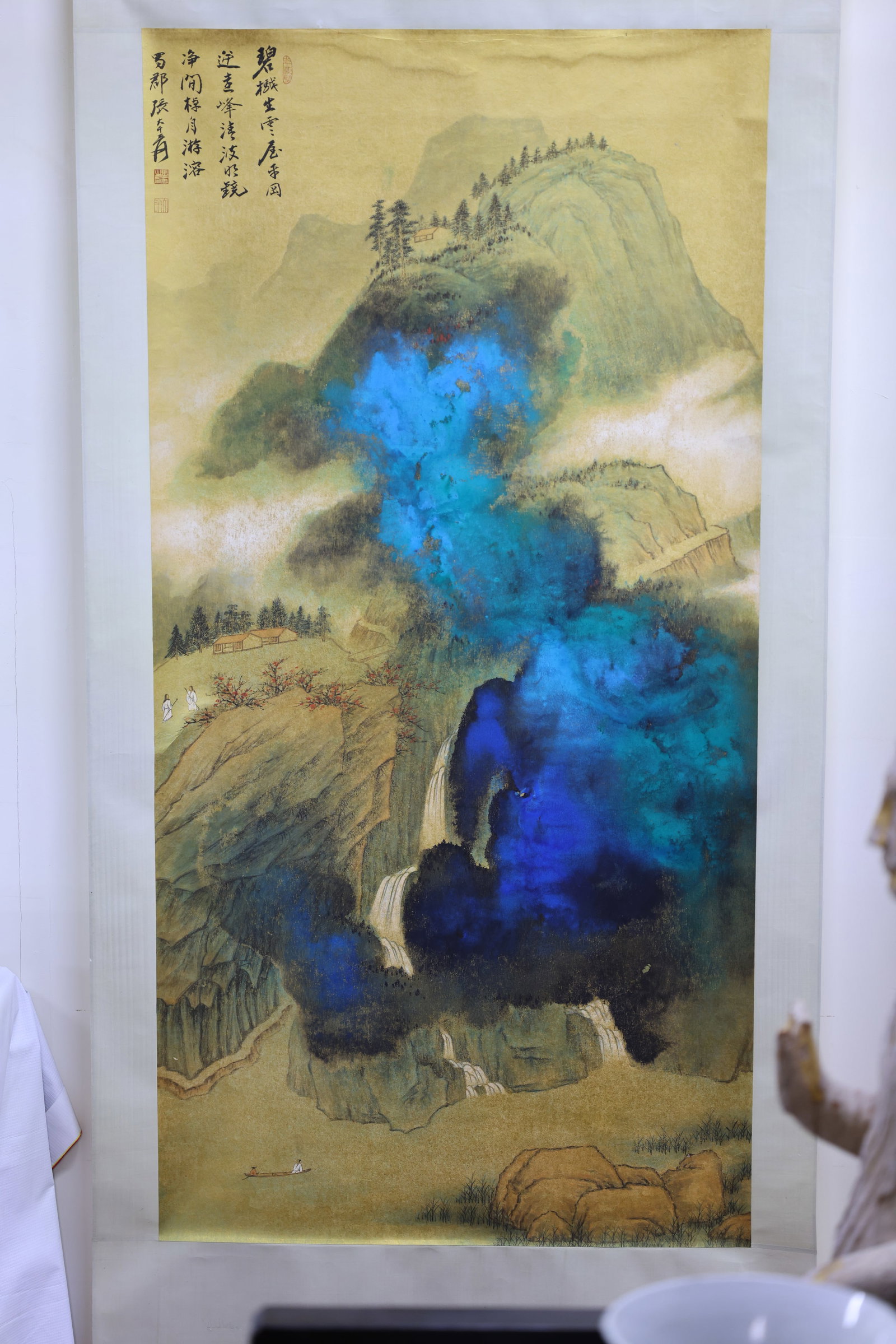 A Magnificent Mounted Hanging Scroll of 'Splashed-Color Landscape along the Stream', Ink and Color: Estimated Date: Modern period. An ink and color landscape hanging scroll in the style of Zhang Daqian.Attribution: Executed in ink and color on gold-flecked paper, the hanging scroll depicts a dramati