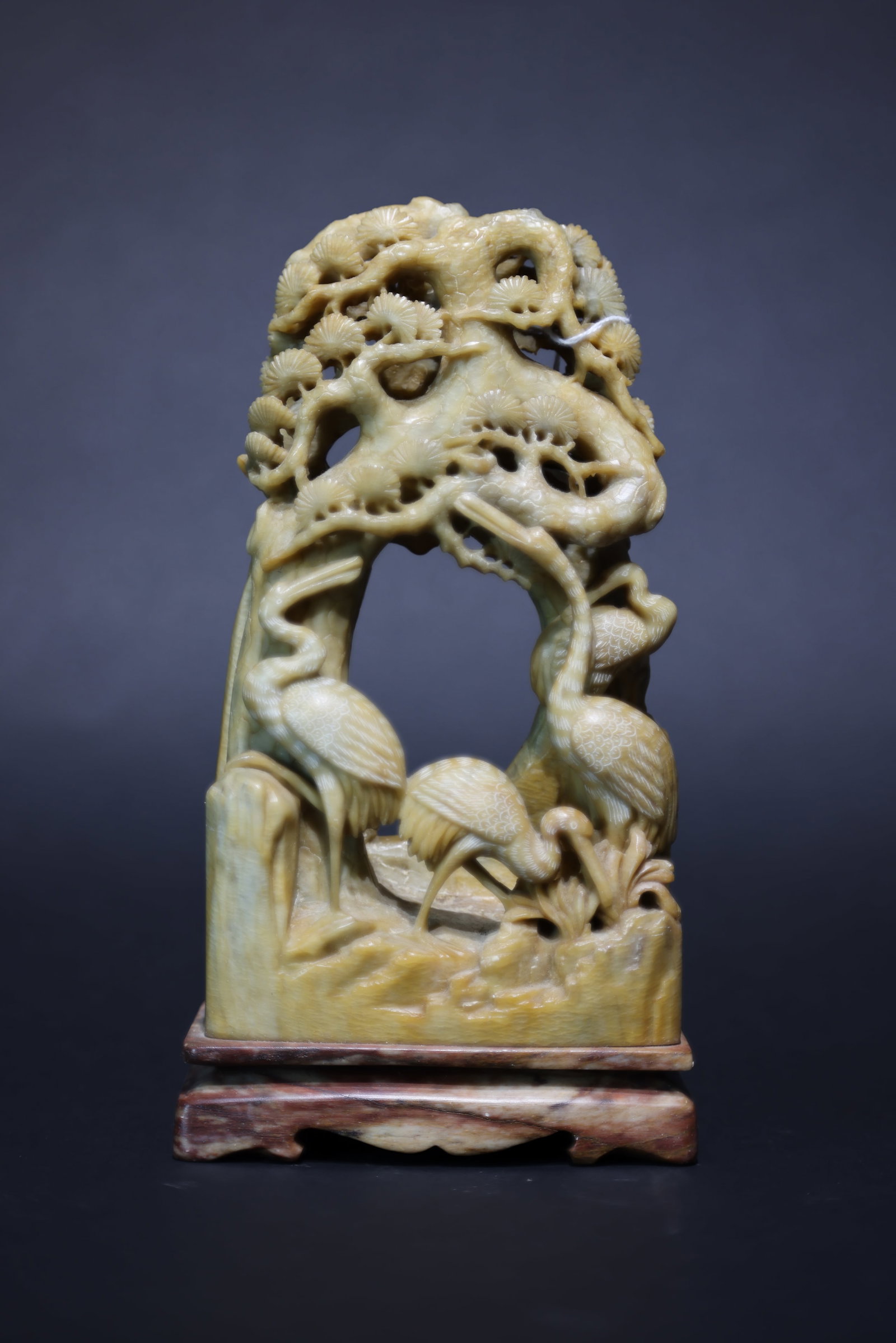 A Shoushan Stone Openwork Carving of 'Pine and Cranes', Qing Dynasty: Estimated Date: Late Qing Dynasty. A carved Shoushan stone "Pine and Cranes" display sculpture.Attribution: Expertly carved from a single piece of yellow Shoushan stone, the sculpture is executed in e
