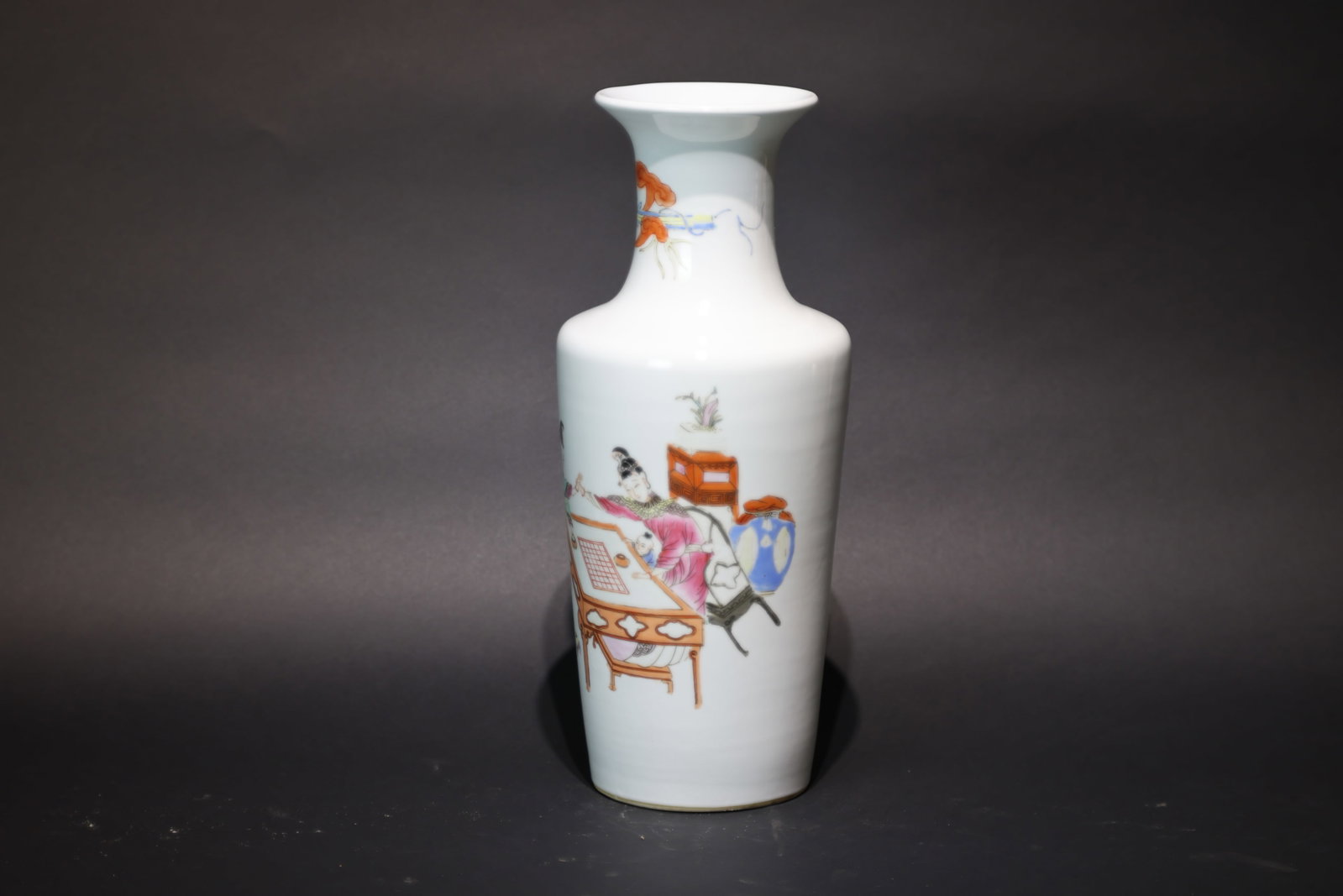 A 'Famille-Rose' 'Ladies Playing Weiqi' Oand-Neck Rouleau Vase, Late Qing Dynasty: Estimated Date: Guangxu Period, Late Qing Dynasty. A famille rose porcelain rouleau vase.Attribution: The vase is of elegant rouleau (bangchui) form with a tall, slender body supported on a flat foot.