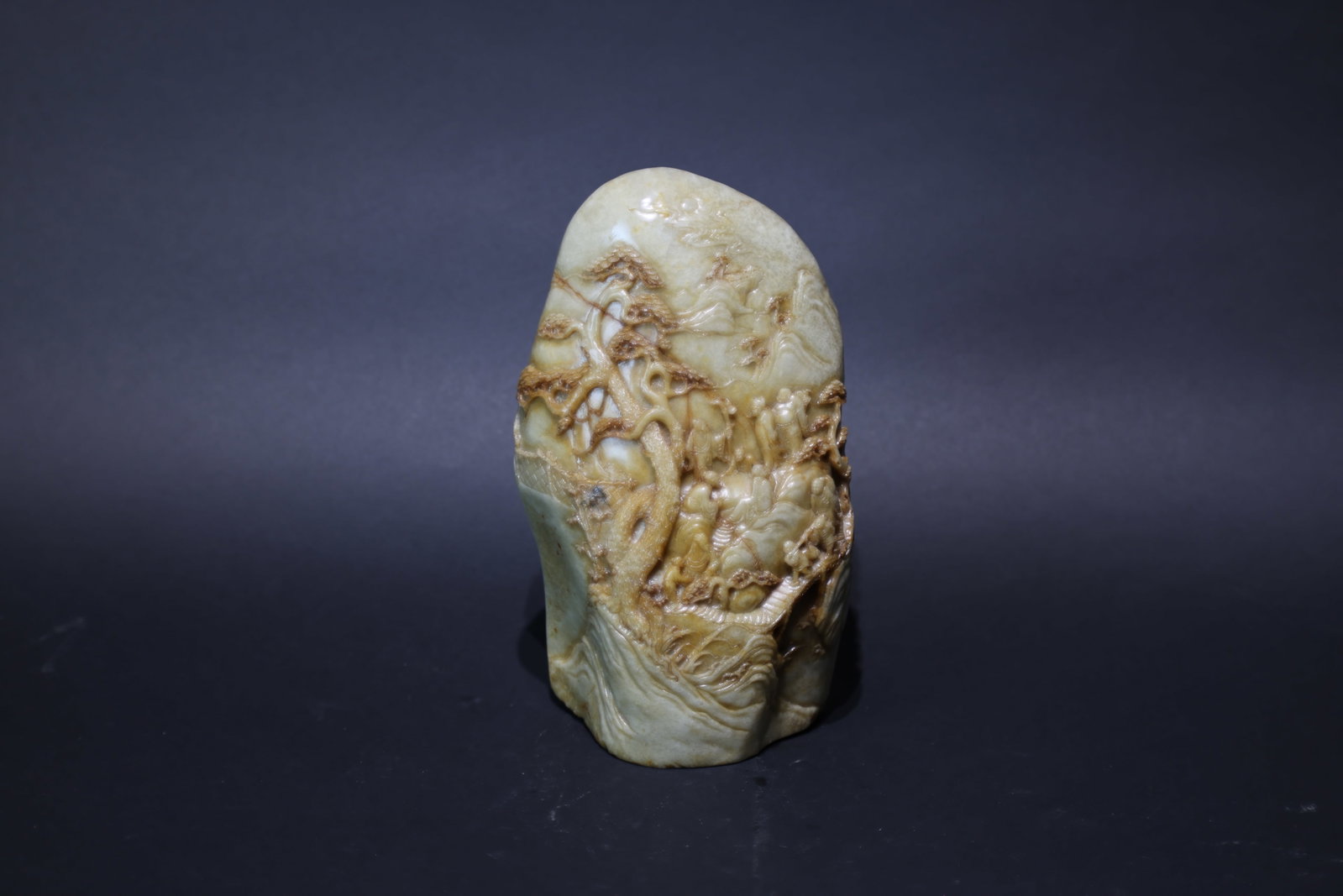A Fine 'Hetian' Jade 'Landscape and Figures' Jade Mountain, Qing Dynasty: Estimated Date: Mid to Late Qing Dynasty. A Hetian seed-jade landscape scholar's mountain (yushanzi).Attribution: The carving is fashioned from Hetian celadon-white seed jade (ziliao) retaining attrac