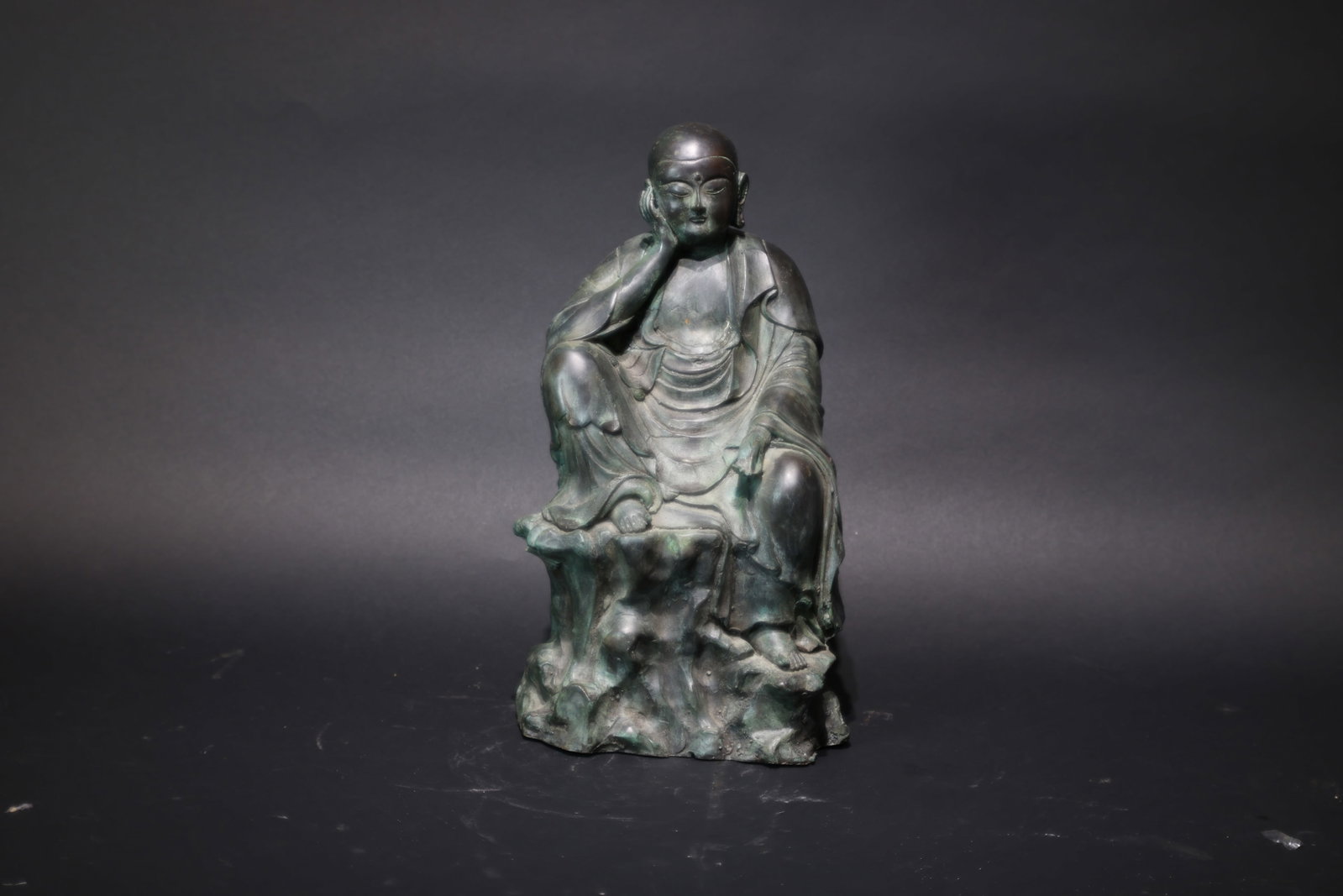 A Bronze Figure of a Meditating Luohan, Qing Dynasty: Estimated Date: Late Qing Dynasty. A bronze figure of a Luohan (Arhat).Attribution: Cast in bronze using the traditional lost-wax hollow-casting technique, the sculpture portrays a Luohan (Arhat) seat