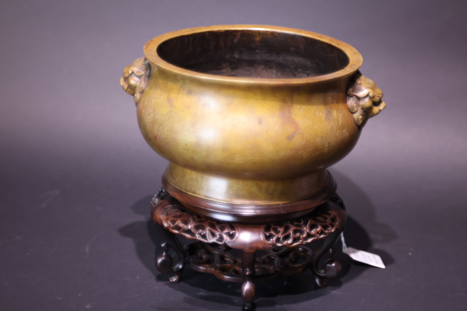 A 'Xuande' Mark Bronze 'Figures' 'Auspicious Beast' Ring-Handled Censer, Late Qing Dynasty: Estimated Date: Late Qing Dynasty. A bronze incense burner in the Xuande style with lion-mask handles, bearing an apocryphal Xuande reign mark.Attribution: Cast in bronze in imitation of the celebrate