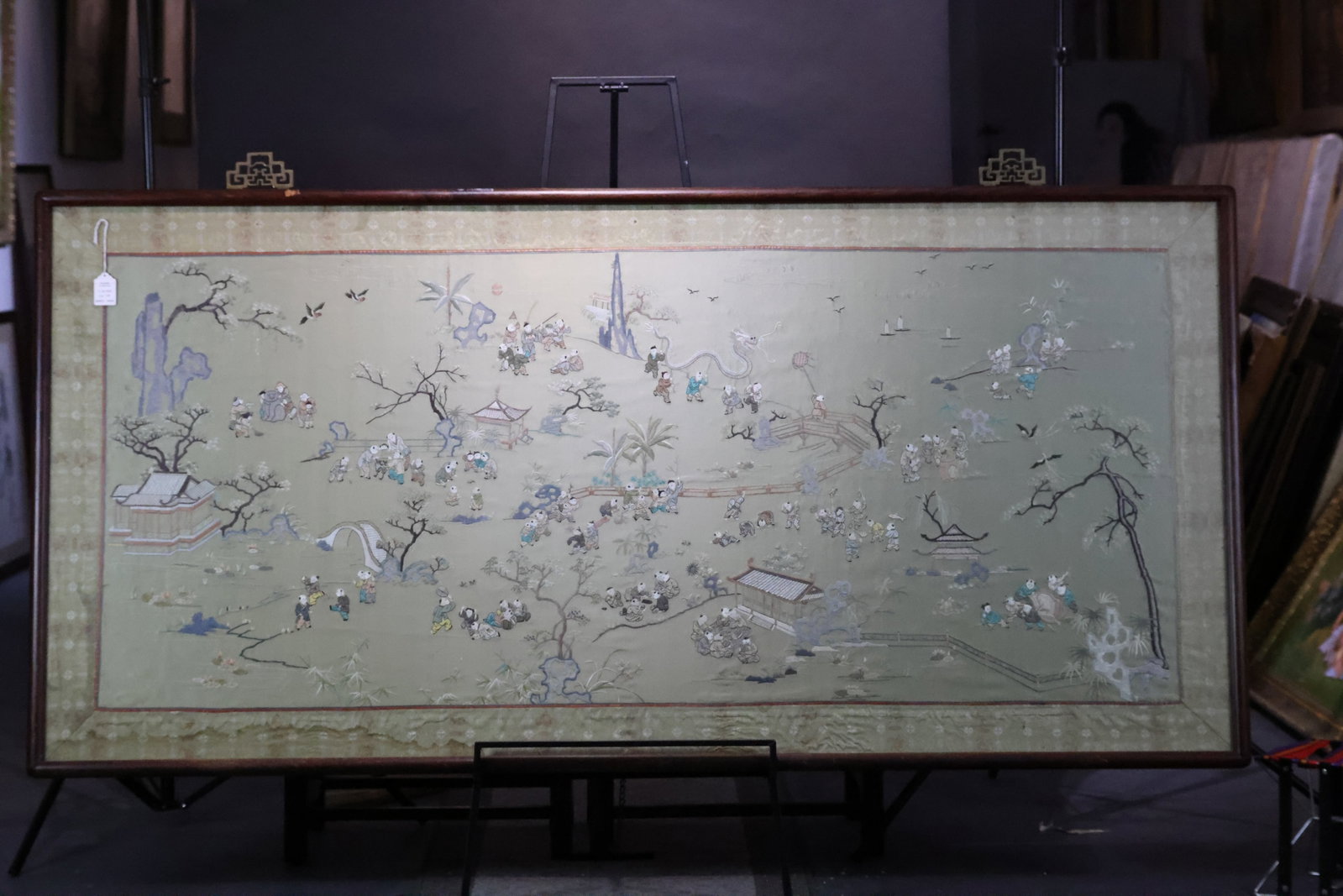 An Important Large 'Hundred Boys' Green Satin-Ground Suzhou Silk Embroidery Hanging Plaque, Qing: Estimated Date: Late Qing Dynasty. A Suzhou embroidery (Su Xiu) “One Hundred Children” panel, mounted in its original hardwood frame.Attribution: Executed on a light celadon-green satin ground
