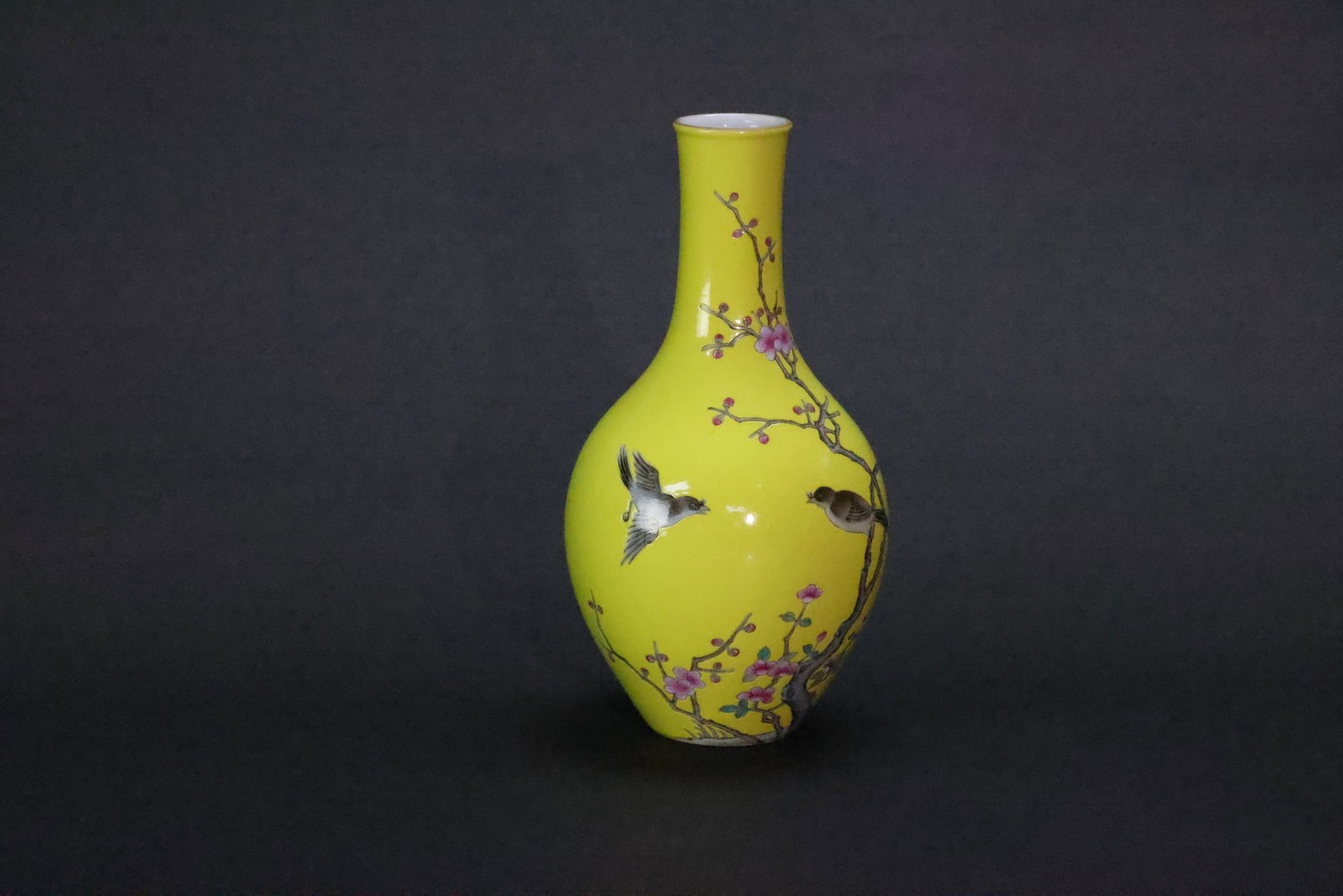 A 'Qing Qianlong' Mark 'Magpies and Plum Blossom' Famille Rose Yellow-Ground Garlic-Mouth Vase,: Estimated Date: Contemporary. A famille rose decorative porcelain vase bearing an apocryphal Qianlong reign mark.Attribution: This decorative porcelain vase is executed in the famille rose palette and