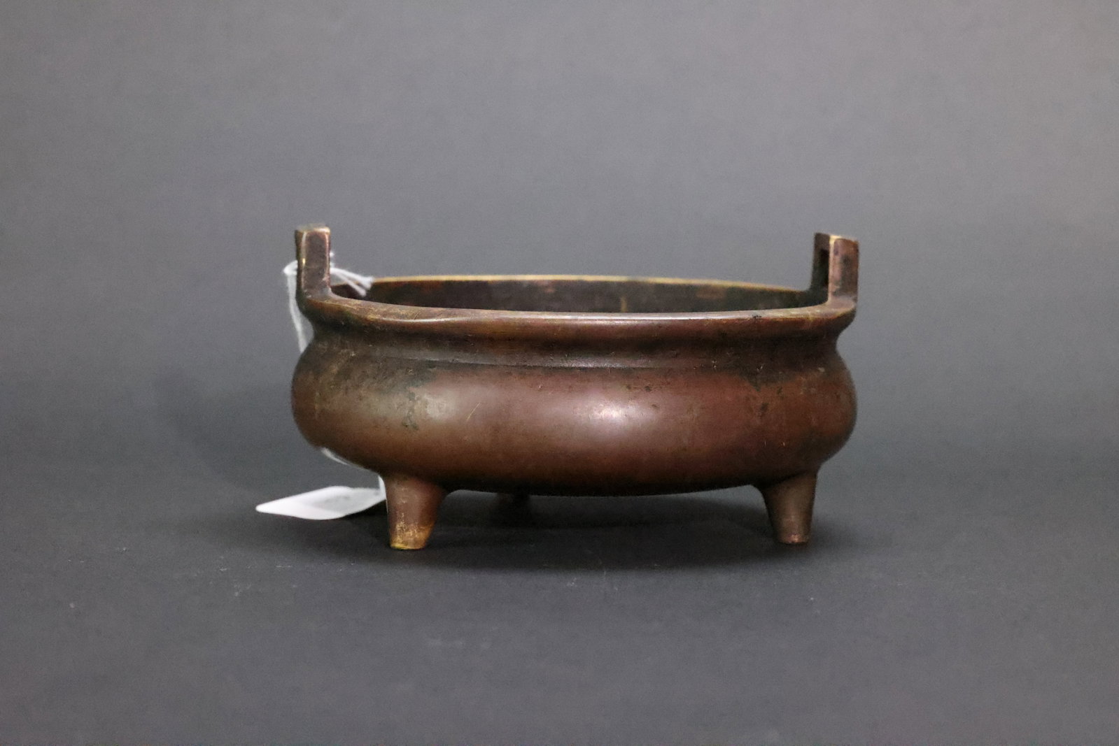 A 'Ming Xuande' Mark Archaistic Bronze 'Chongtianer' Tripod Censer, Qing Dynasty: Estimated Date: Late Qing Dynasty. An archaistic bronze incense burner in the style of Xuande-period censers.Attribution: This finely cast yellow brass incense burner was produced during the late Qing