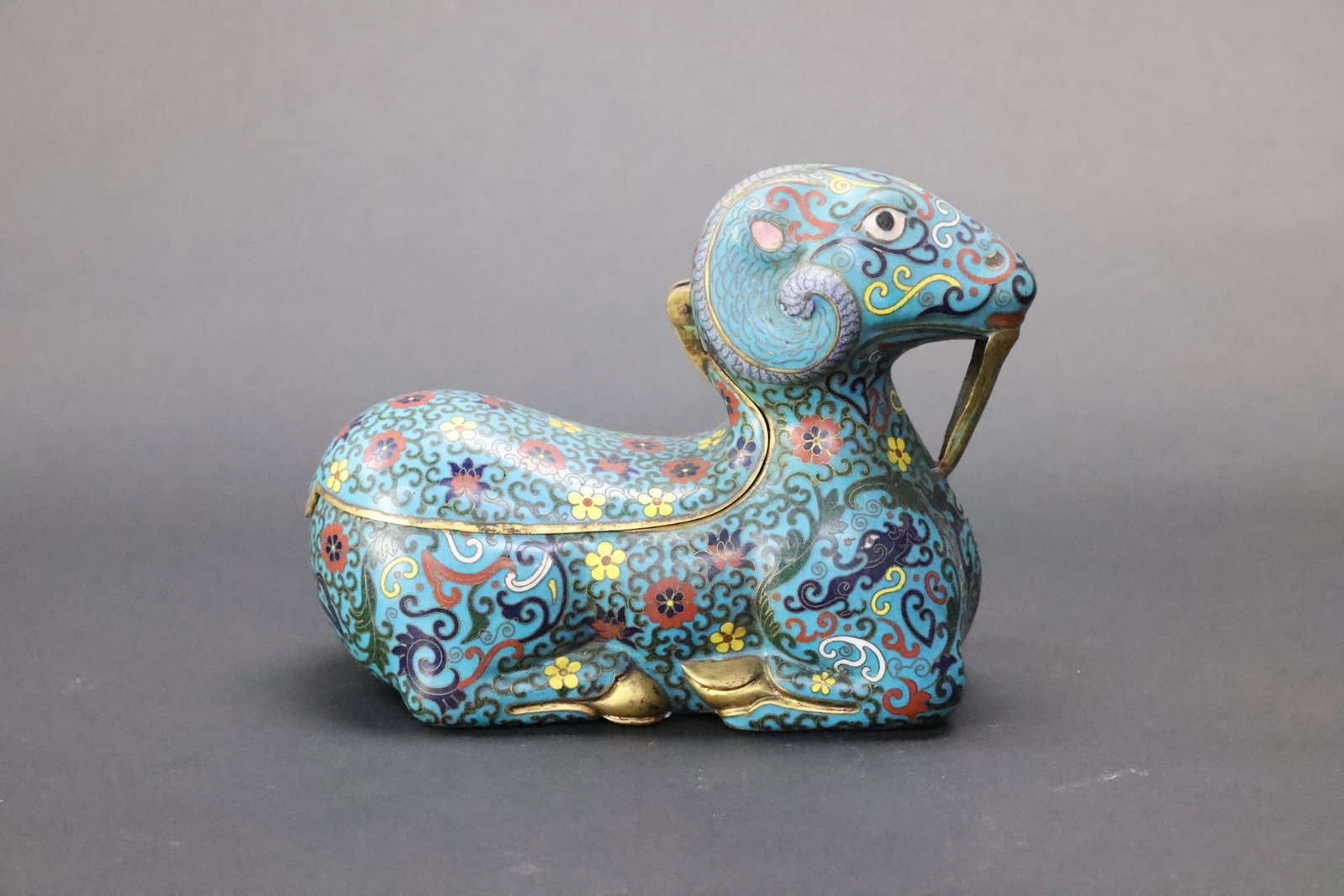 A Cloisonné Enamel 'Recumbent Ram' Box and Cover, Late Qing Dynasty: Estimated Date: Late Qing Dynasty to the Republican period (late 19th–early 20th century). A cloisonné enamel recumbent ram covered box.Attribution: This finely executed cloisonné enamel covered b