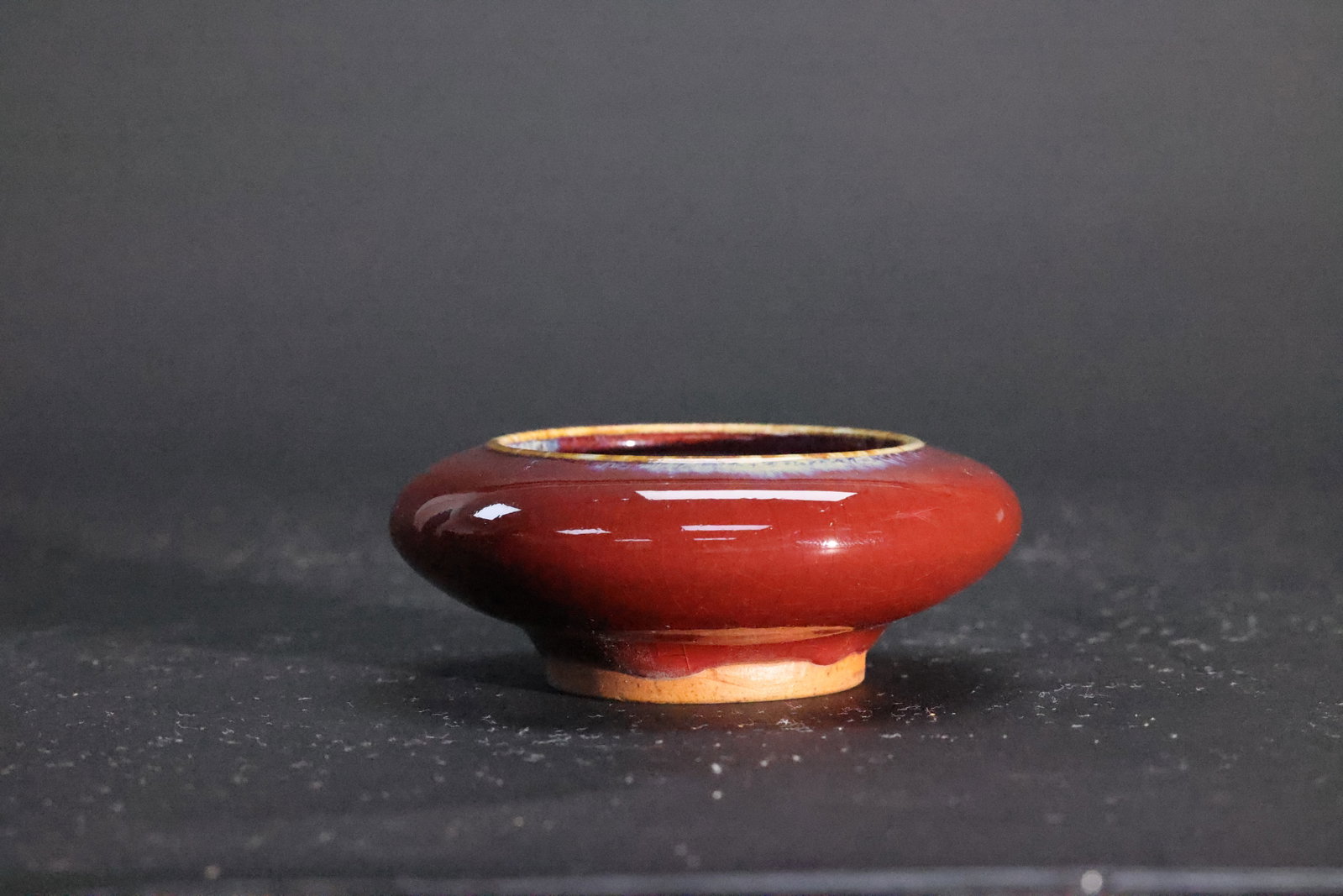 A Jun-Type Flambé-Glazed Compressed Water Pot, Qing Dynasty: Estimated Date: Mid- to Late Qing Dynasty. A Jun-type flambé-glazed scholar's washer.Attribution: This small scholar's washer belongs to the Jun ware tradition and is attributed to the mid- to late Q