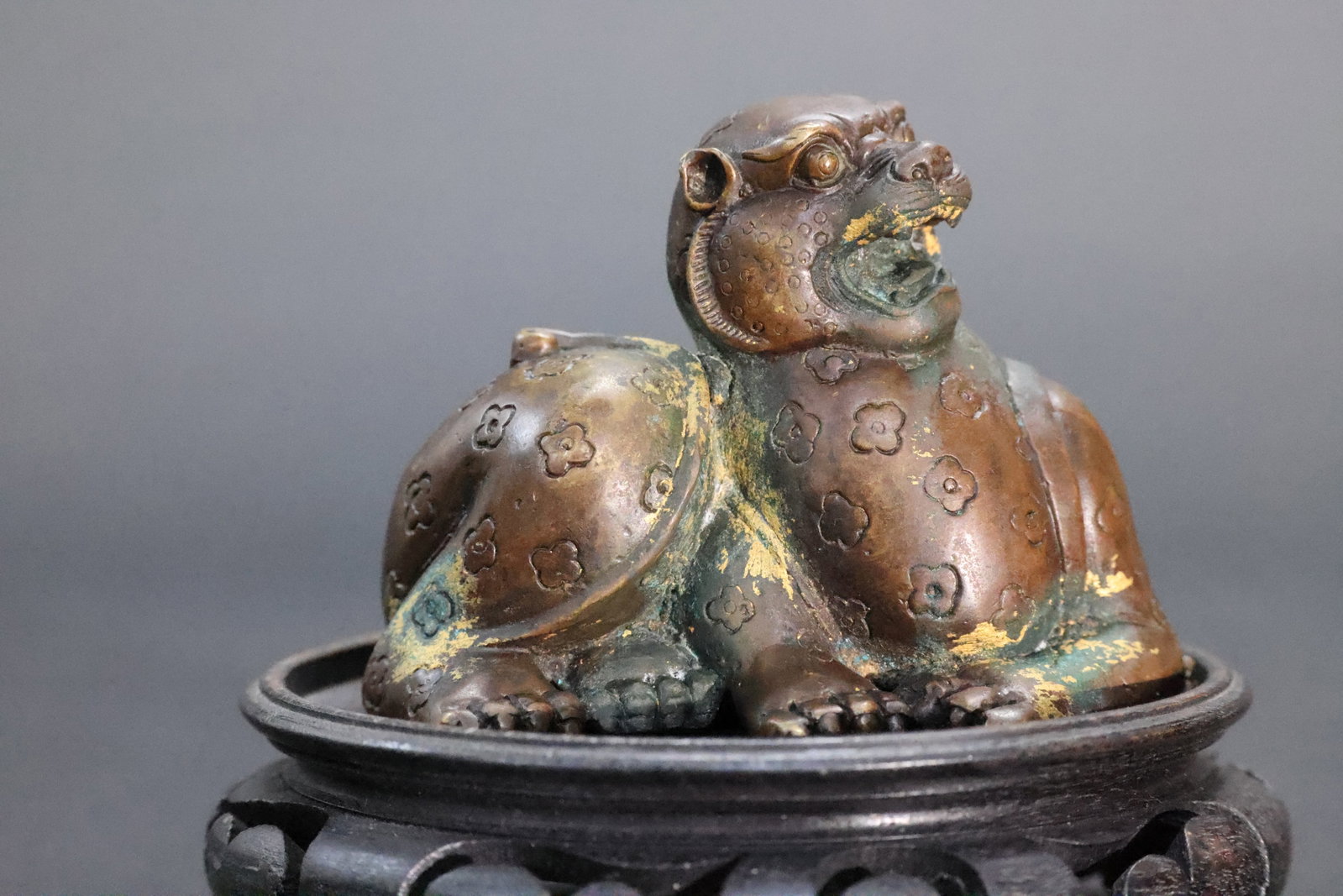 A Parcel-Gilt Bronze 'Prunus and Mythical Beast' Paperweight, Qing Dynasty: Estimated Date: Mid- to Late Qing Dynasty. A gilt-bronze mythical beast paperweight for the scholar's desk.Attribution: This scholar's paperweight was cast in brass during the mid- to late Qing Dynast