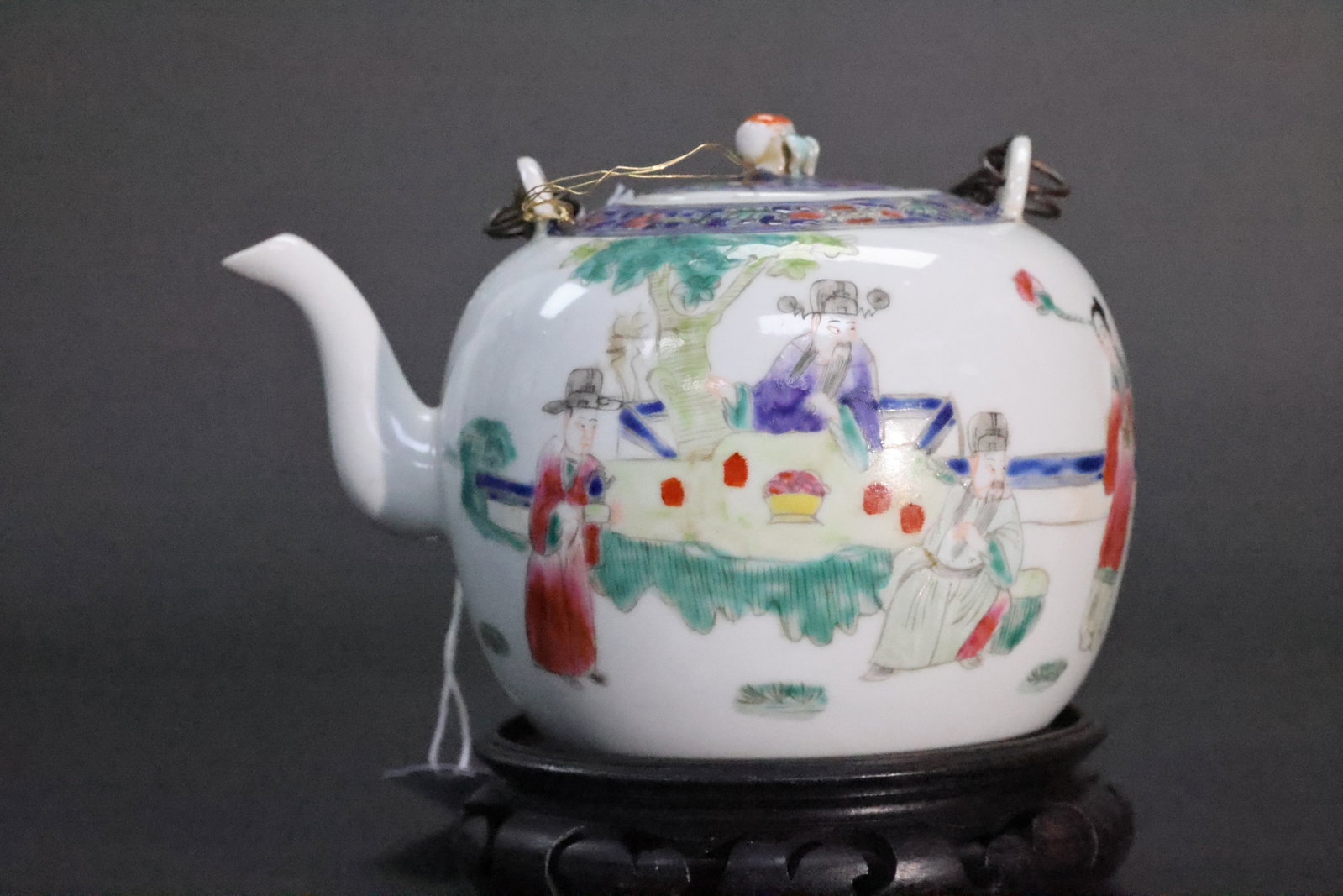 A Famille Rose 'Historical Figures' Globular Teapot with Bronze Handle, Qing Dynasty, Tongzhi Period: Estimated Date: Tongzhi reign, Qing Dynasty (1862–1874). A famille rose figural porcelain teapot with its original copper swing handle.Attribution: This famille rose teapot is attributed to the Tong