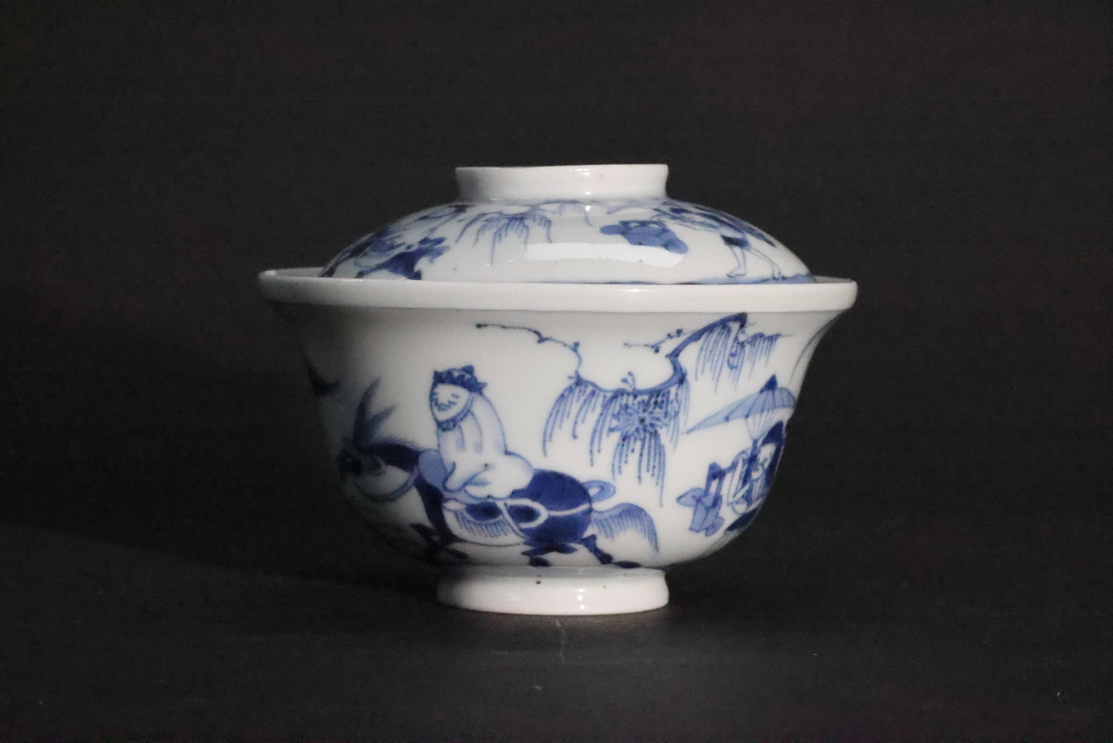A Blue and White 'Looking for Plum Blossoms in the Snow' Lidded Bowl, Late Qing Dynasty: Estimated Date: Guangxu reign, Late Qing Dynasty (1875–1908). A blue-and-white figural sancai covered gaiwan (cover and bowl only, stand missing).Attribution: This blue-and-white porcelain gaiwan is