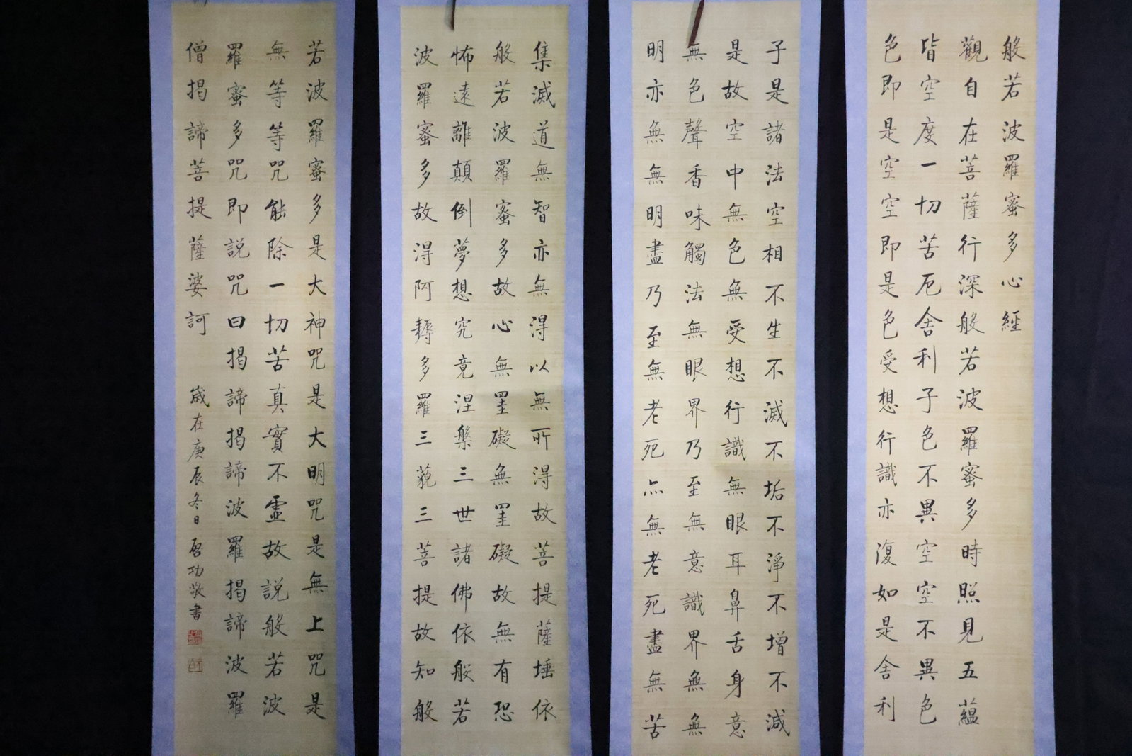 A Set of Four Silk Calligraphy Hanging Scrolls of the Heart Sutra, After Qi Gong: Attribution: A modern silk calligraphy hanging scroll transcribing the Heart Sutra, executed in the style of Qi Gong.Characteristics: The complete text of the Heart Sutra (Prajñ?p?ramit? H?daya S?tra