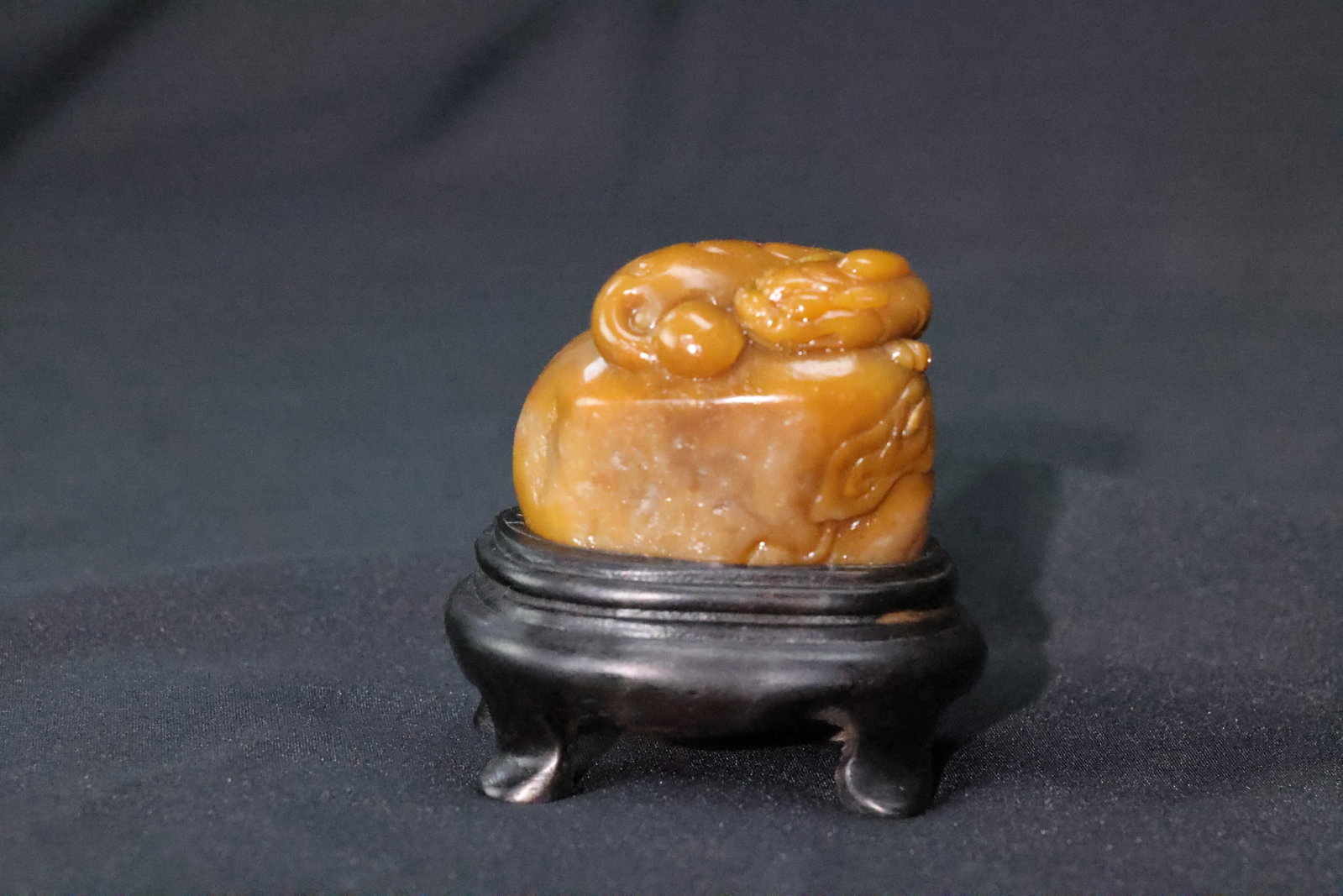 A Shoushan Yellow Stone Seal Blank with Chilong Knop: Estimated Date: Modern. A Shoushan stone seal blank with an archaistic beast finial.Attribution: This decorative seal stone is carved from warm yellow translucent Shoushan stone, displaying a smooth,