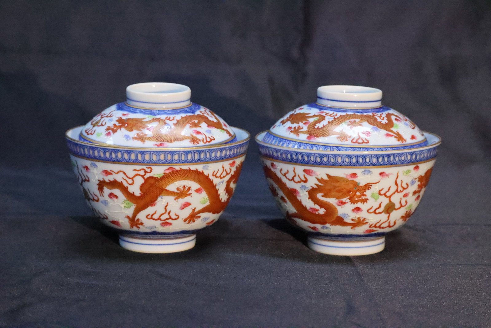 A Pair of Famille Rose and Iron-Red 'Dragon' Covered Bowls: Estimated Date: Modern, bearing a Guangxu reign mark. A covered porcelain bowl (gaiwan) in the Guangxu imperial style.Attribution: This two-piece covered bowl is decorated on a white ground with