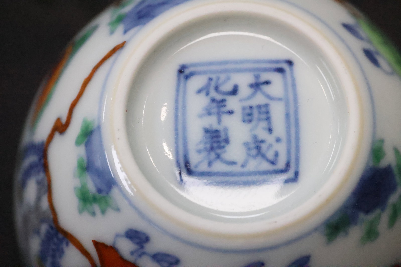 A Doucai 'Landscape and Figures' Cup: Estimated Date: Modern, bearing a Chenghua-style reign mark. A doucai 'Scholar in a Landscape' stemless cup.Attribution: This small doucai porcelain cup is finely potted in white porcelain and decorat