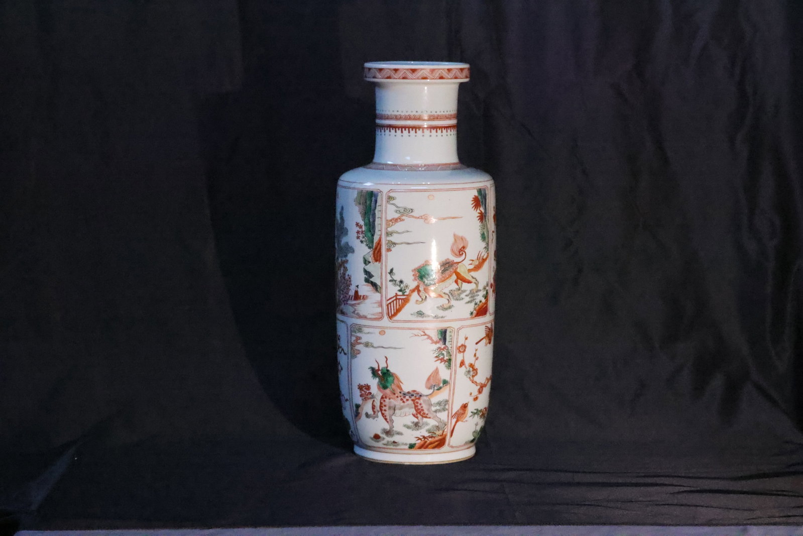 A Wucai 'Landscape, Figures and Mythical Beasts' Rolwagen Vase: Estimated Date: Modern, in the Qing Dynasty wucai style. A large wucai rouleau vase with panel decoration.Attribution: This impressive rouleau vase is of the classic form with a flared mouth,