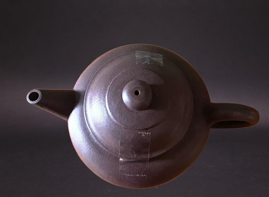 A Zisha 'Duoqiu' Teapot: Estimated Date: Modern. A Yixing stoneware teapot bearing the "Danran Zhai" mark.Attribution: This Yixing stoneware teapot bears the studio mark "Danran Zhai" . The vessel displays the clean proportio