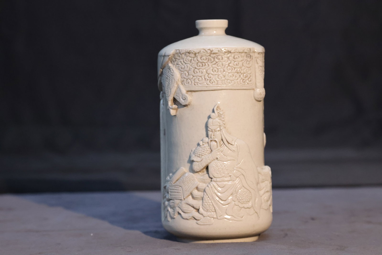 White Porcelain High-Relief Cylindrical Vase with Guan Yu Reading the Spring and Autumn Annals, Wang: Auction Reference: Authentic carved porcelain vases by Wang Bingrong have realized tens of thousands to well over one hundred thousand RMB at auction, depending on artistic quality, provenance, and co
